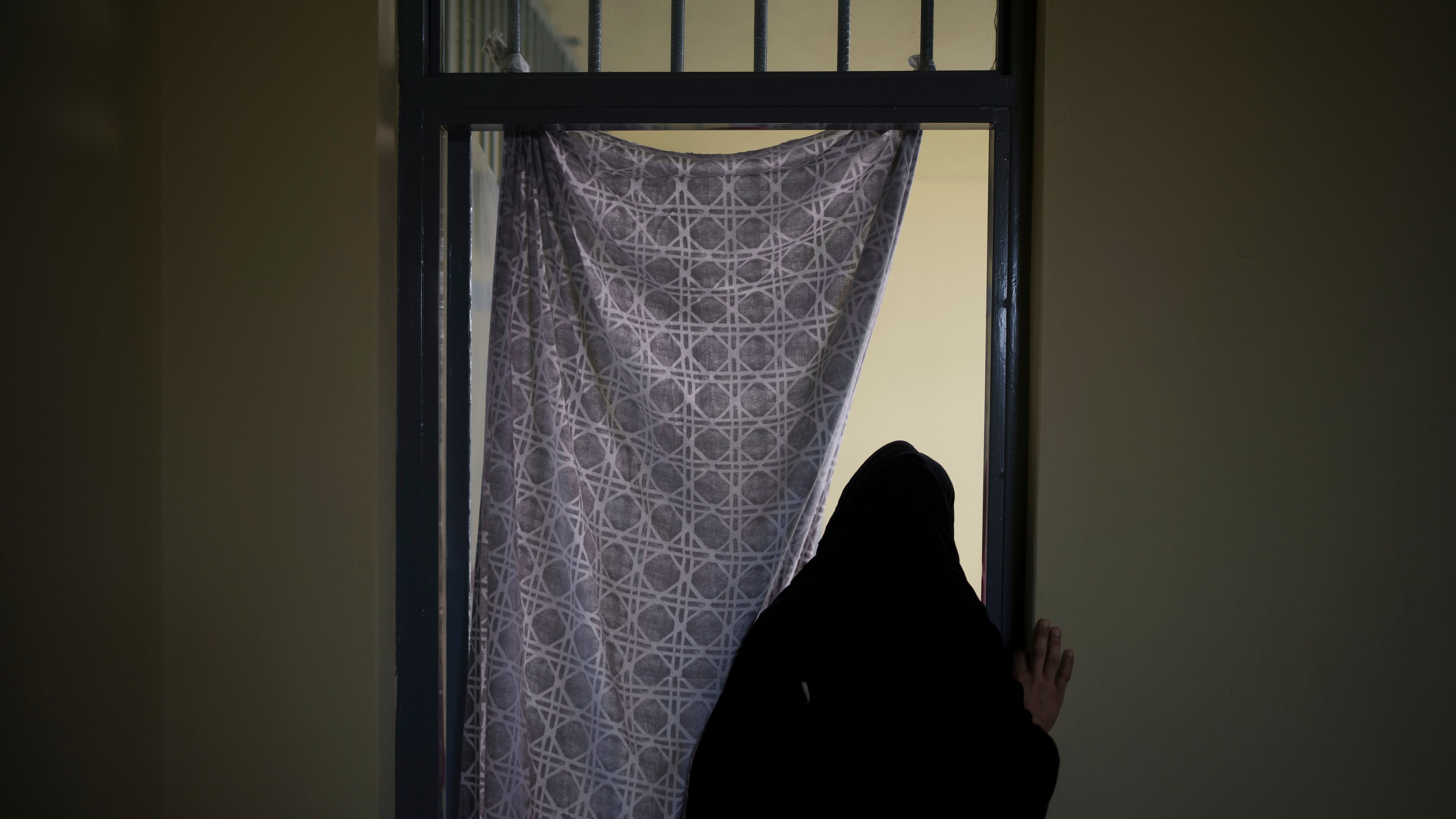 FILE - An Afghan woman walks out of a cell inside the women's section of the Pul-e-Charkhi prison in Kabul, Afghanistan, on Sept. 23, 2021. (AP Photo/Felipe Dana, File)