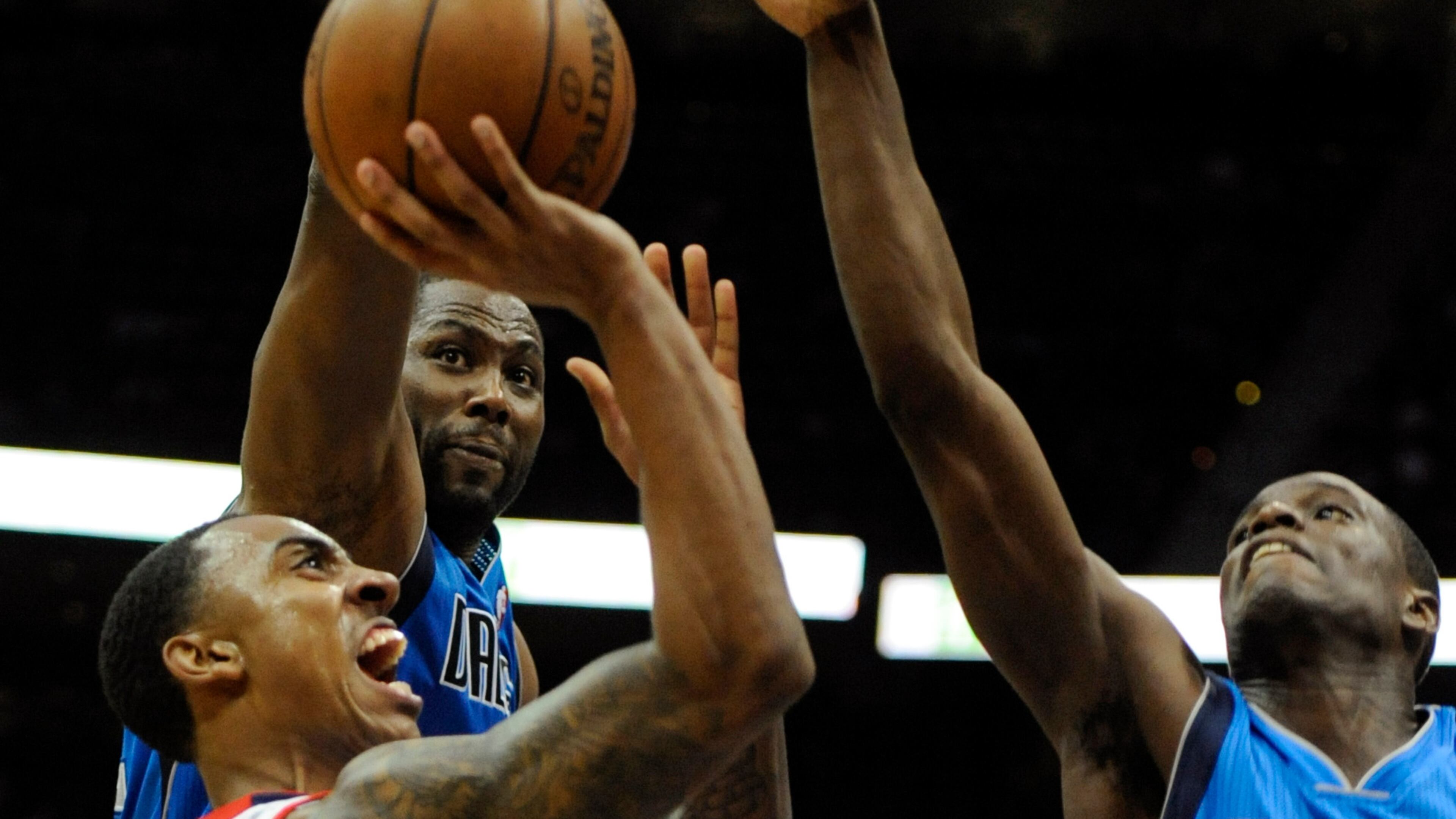 Atlanta Hawks guard Jeff Teague, left, shoots as Dallas Mavericks forward Elton Brand, and point guard Darren Collison, right, defend during the first half of an NBA basketball game, Monday, March 18, 2013, in Atlanta. (John Amis/AP Photo)