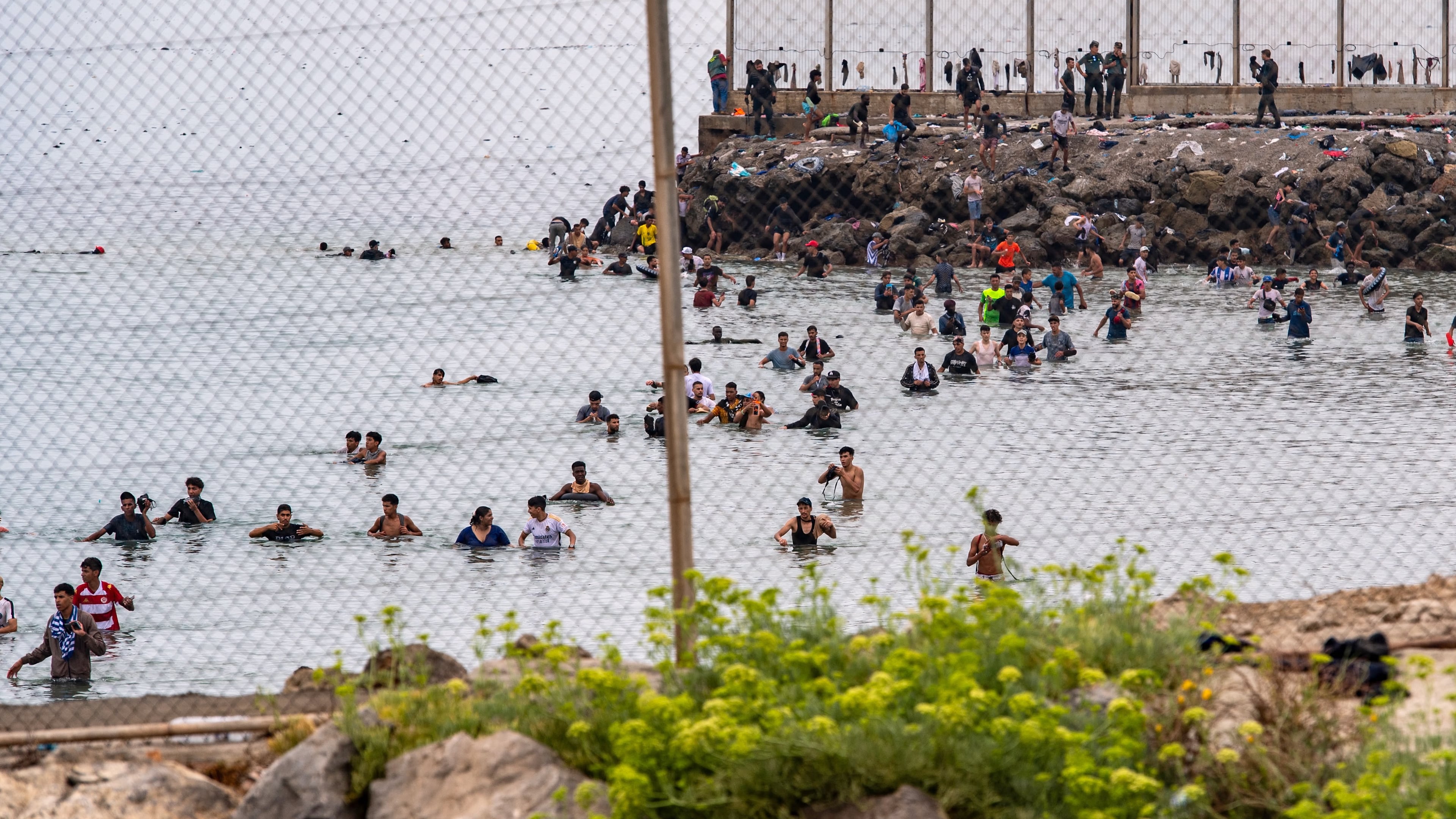 Migrants try to cross from Morocco into the Spanish enclave of Ceuta, Friday, July 31, 2026. (AP Photo/Antonio Sempere)