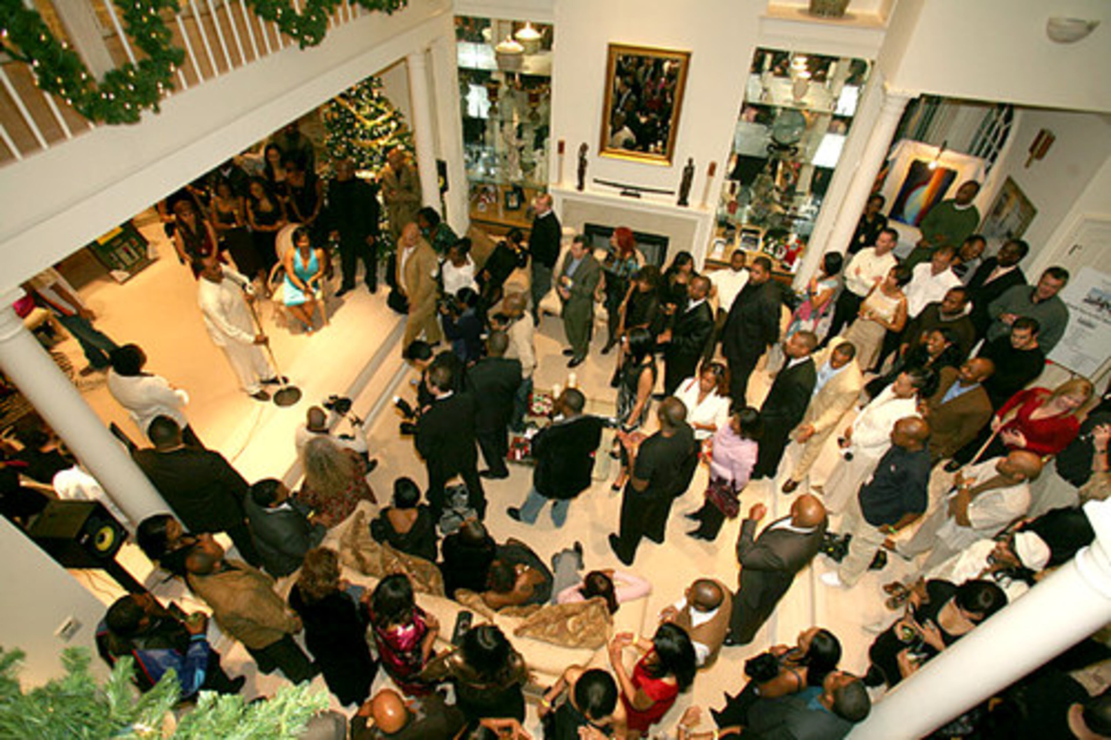 Guests fill the living room for the live auction of sports memoriablia, wine and art.