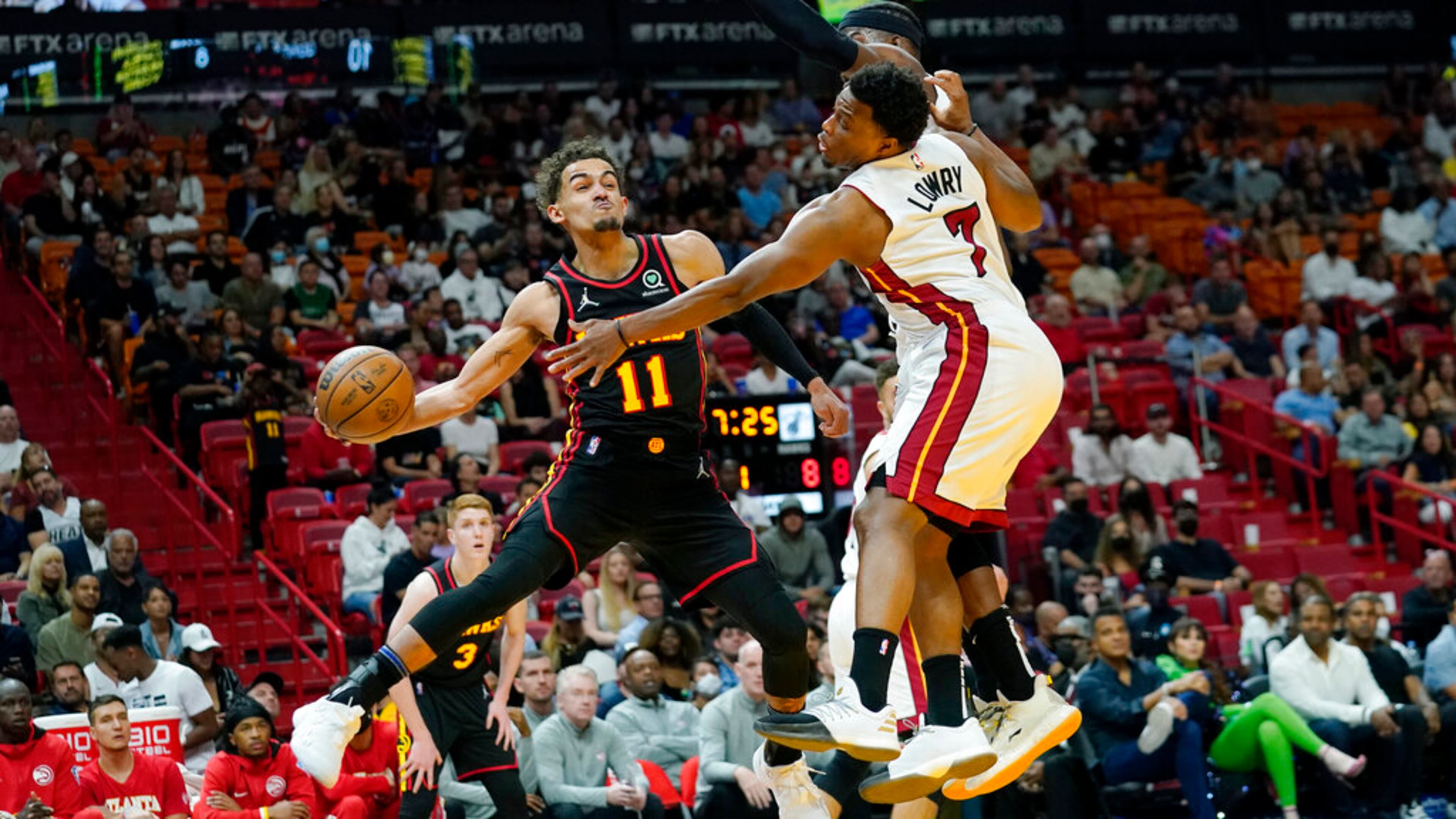 Atlanta Hawks guard Trae Young (11) passes the ball as Miami Heat guard Kyle Lowry (7) defends during the first half of an NBA basketball game Friday, April 8, 2022, in Miami. (AP Photo/Lynne Sladky)