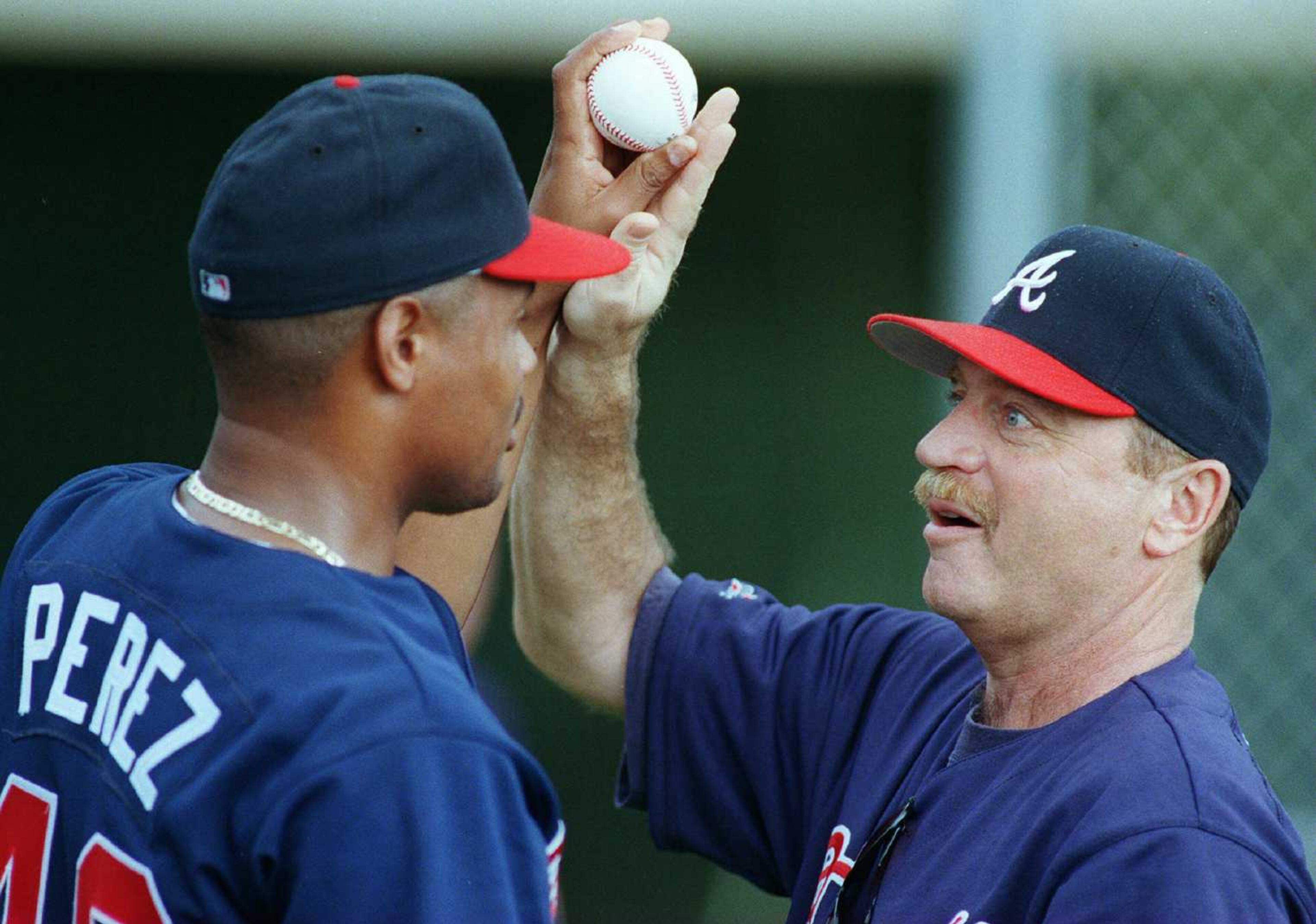 Mazzone (right) works with Yorkis Perez on his technique.