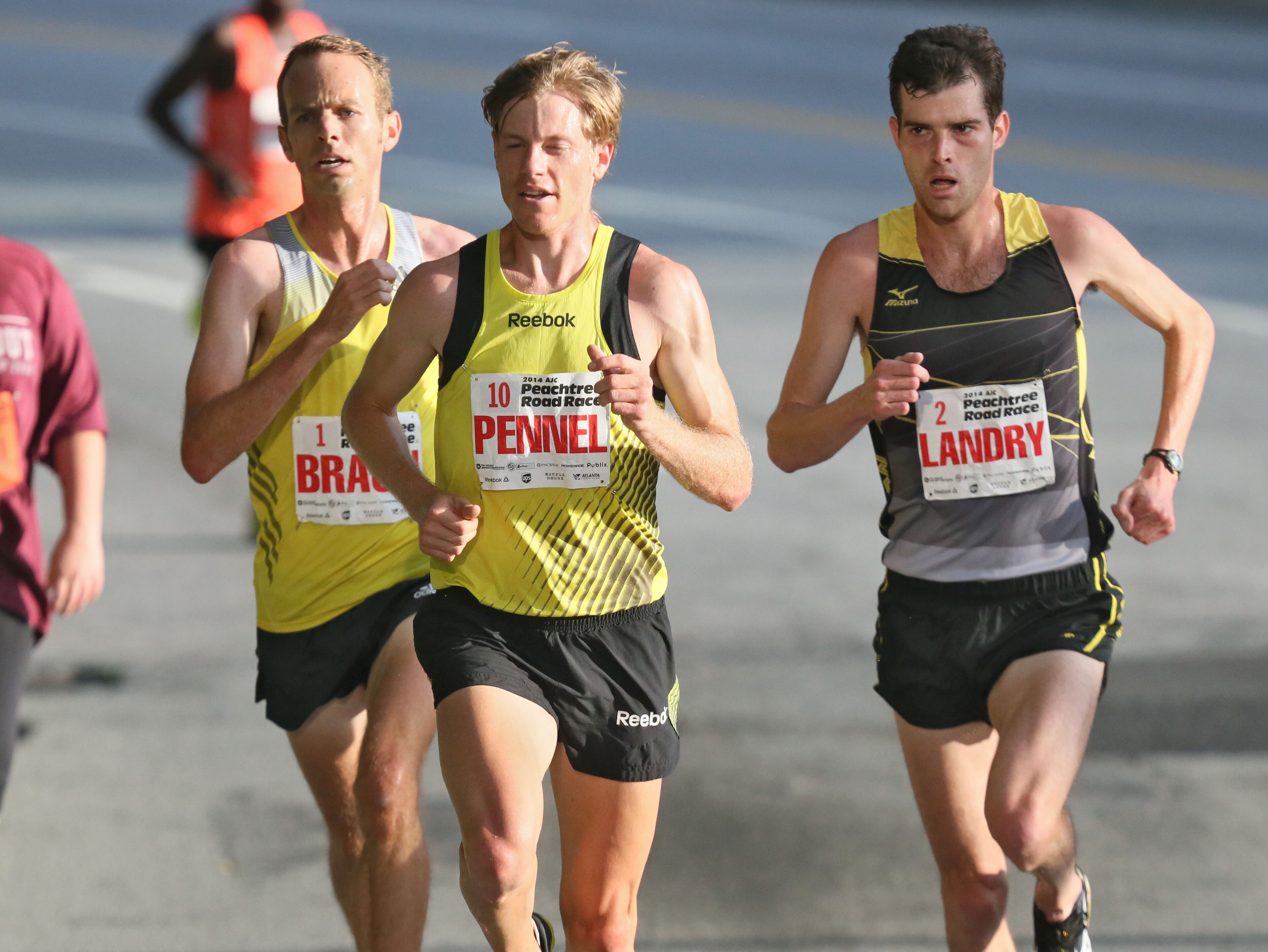 Christo Landry (right), the eventual winner, gets ready to take the lead over Tyler Pennel, who finished second, and Aaron Braun, 4th. The 45 running of the AJC Peachtree Road Race Friday morning July 4, 2014, in Atlanta, Ga.. BOB ANDRES / BANDRES@AJC.COM