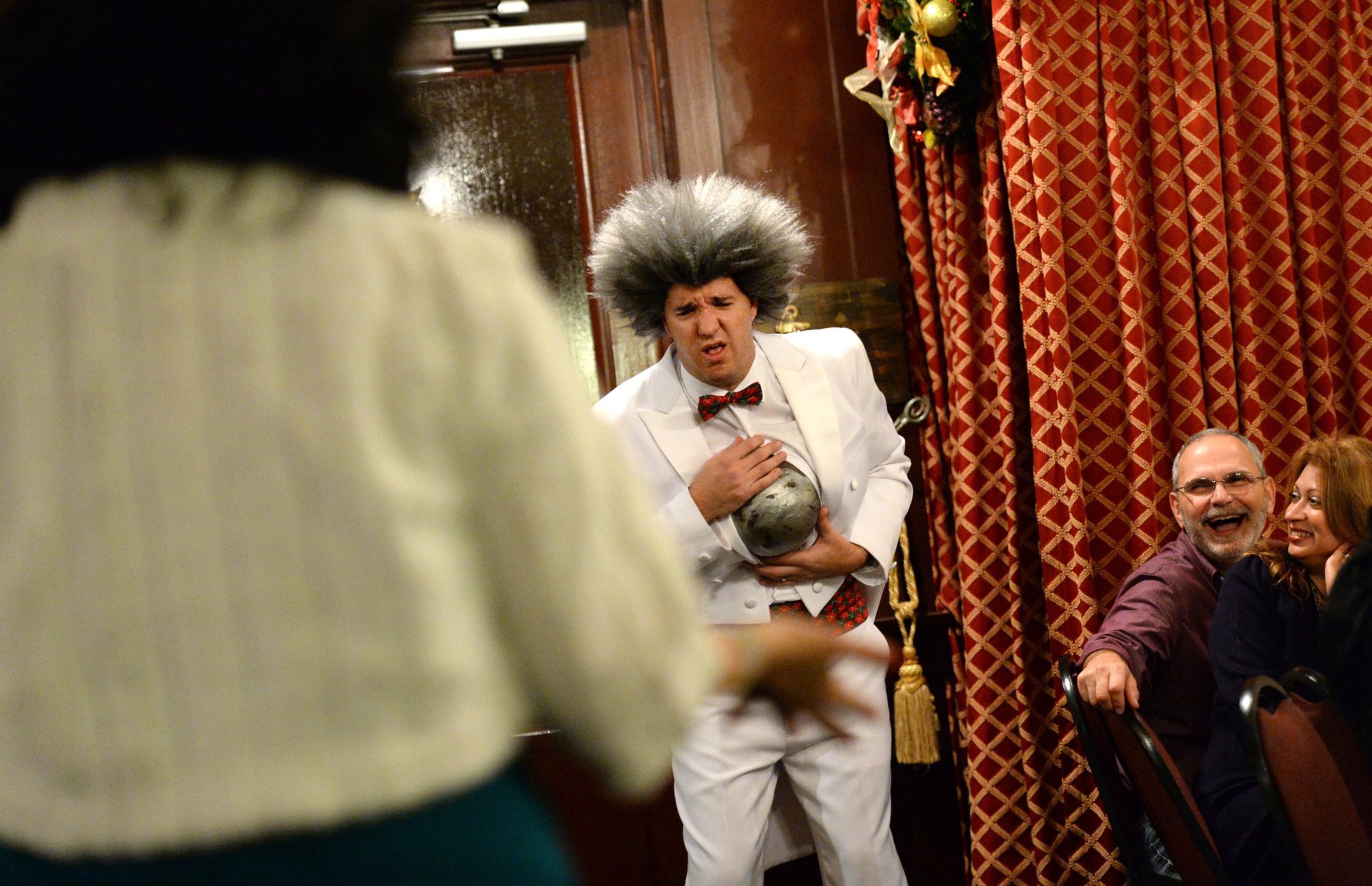 Travis and Lizzette Langley (right), of Cumming, appear to enjoy the performance by Ryan Girard (in the role of Bubba Van Peterbuilt) during "The Nut Croaker Ballet: Murder on Your Toes" at Agatha’s A Taste of Mystery dinner theater in 2013. (Hyosub Shin/AJC)