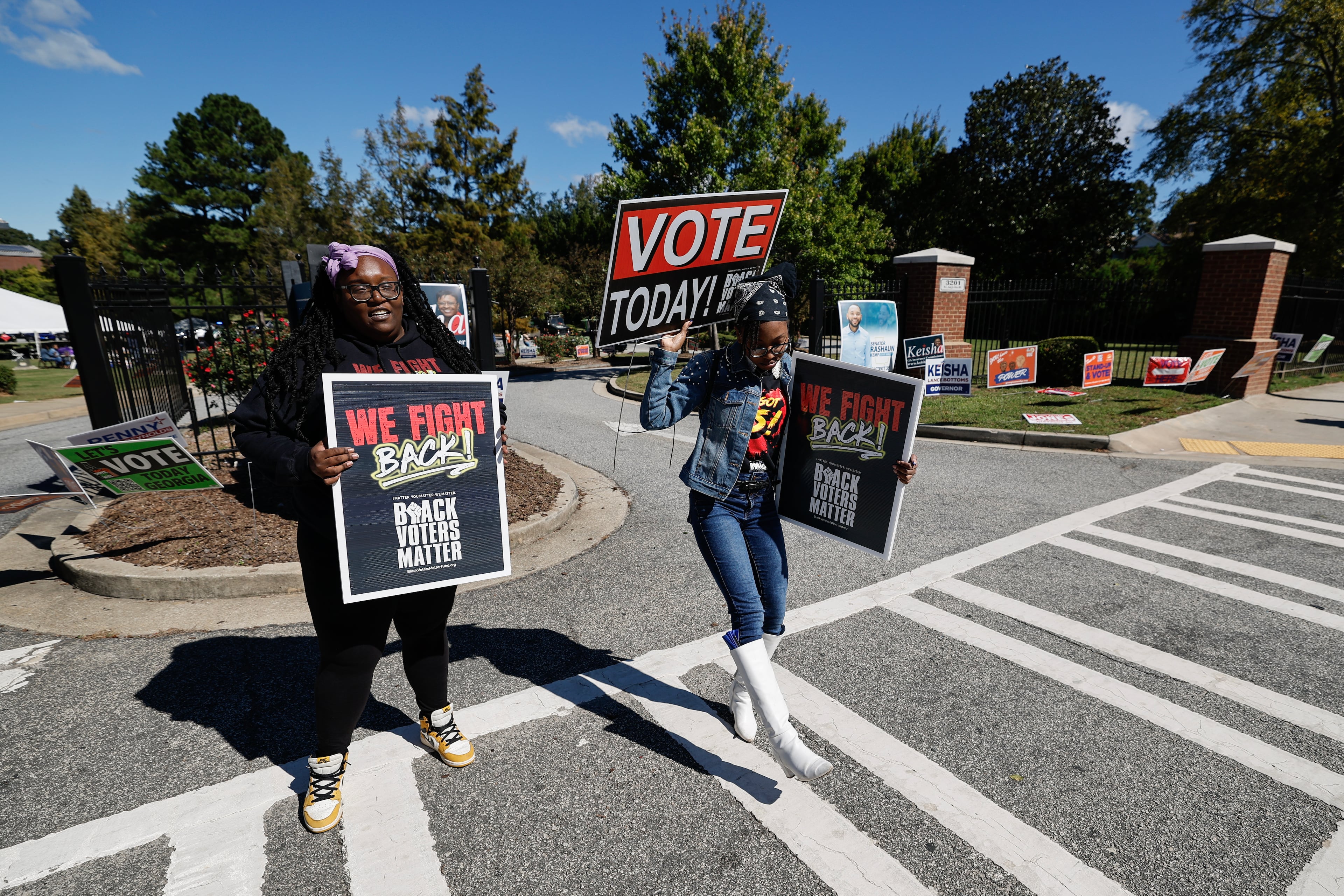 Volunteers encourage drivers to cast their ballot during a Black Voters Matter “No Kings: Vote Early Atlanta” event at the C.T. Martin Natatorium and Recreation Center, a Fulton County early voting location, on Saturday, Oct. 17, 2026, in Atlanta. (Erik S. Lesser for the AJC)