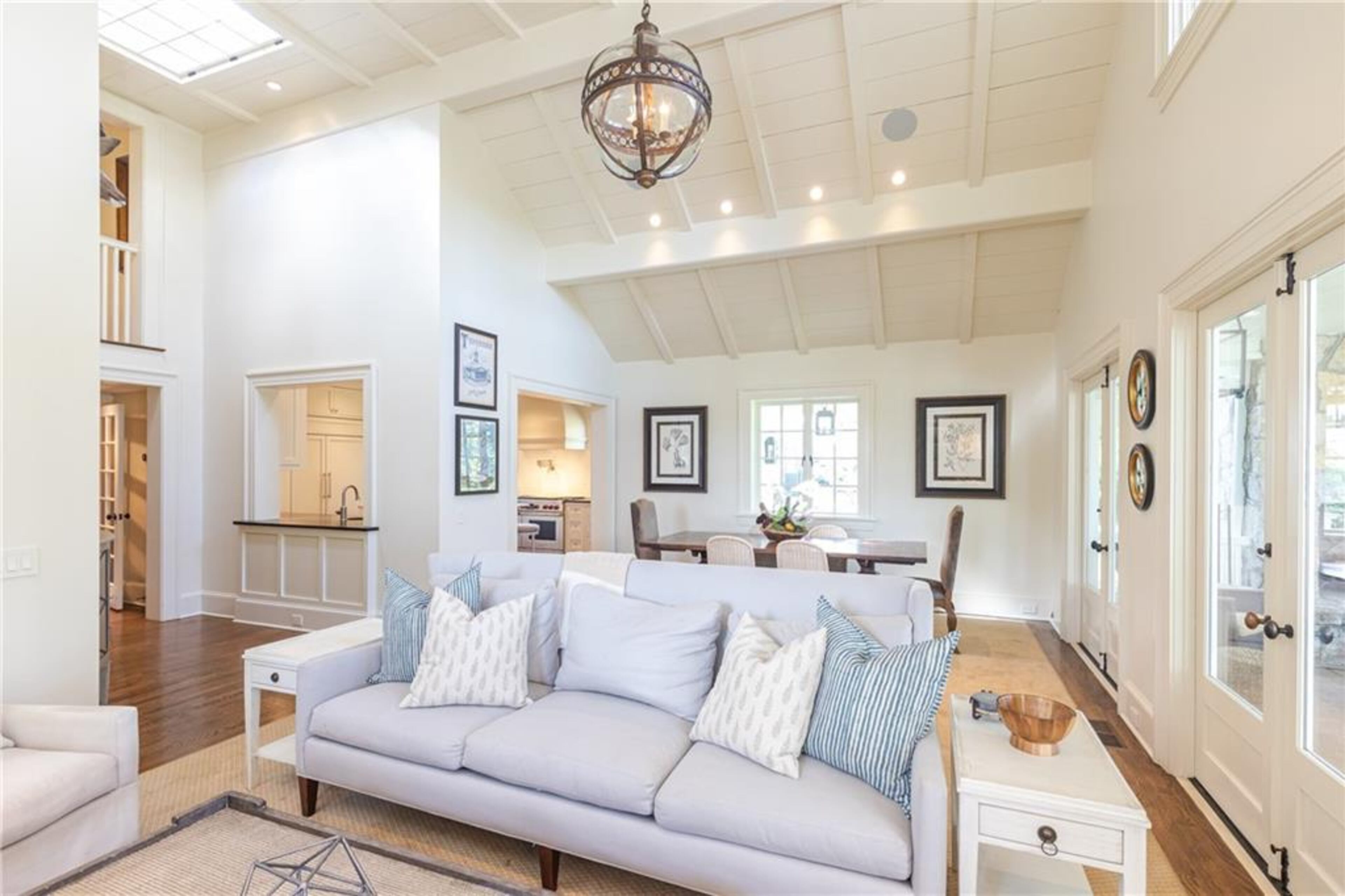 High, nickel gap wood panel ceilings and sky lights illuminate's this living space which adjoins the screened-in porch and outdoor, wood burning fireplace.