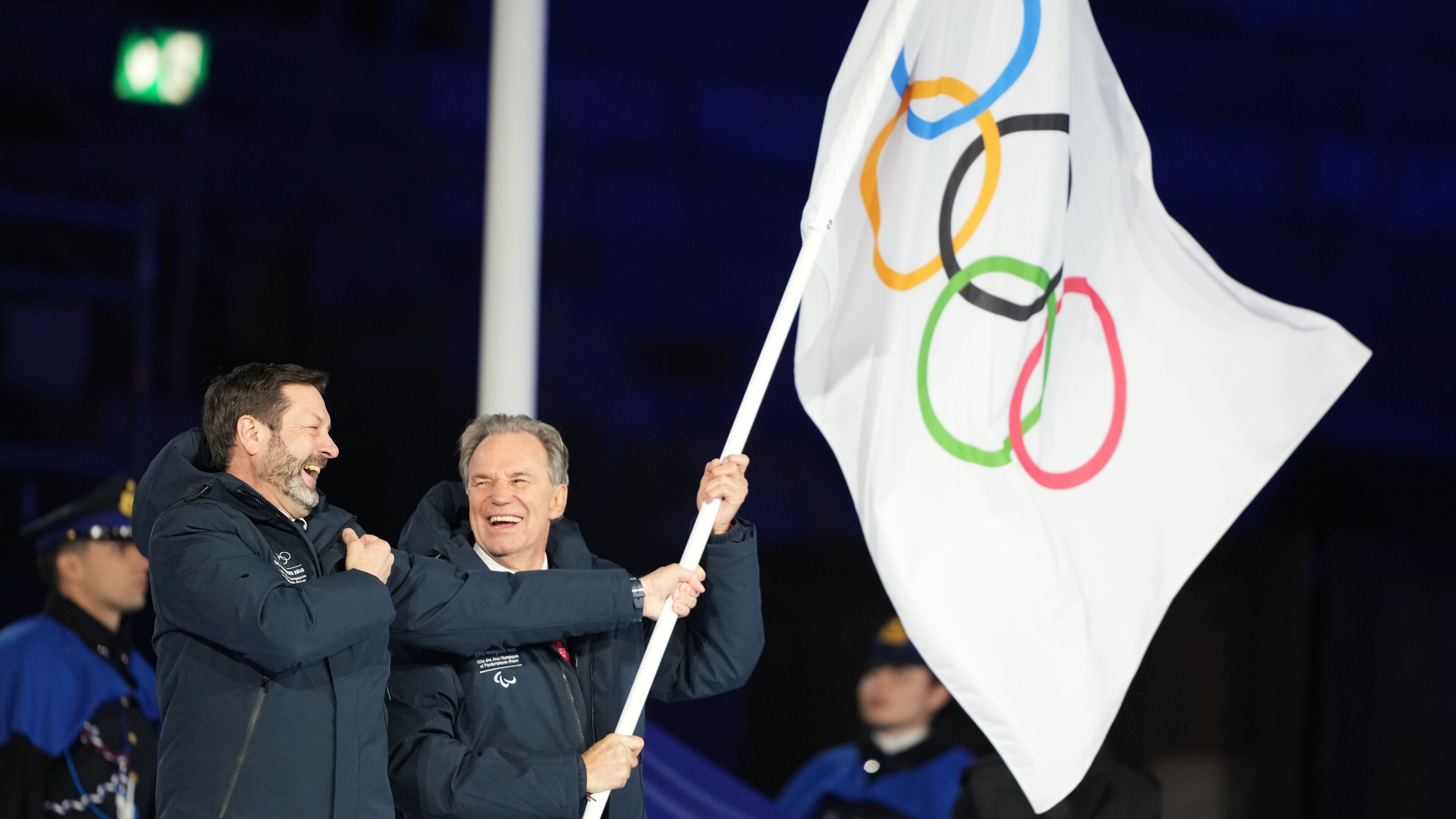 President of the Provence-Alpes-Cote d'Azur Region Renaud Muselier, right, and President of the Auvergne-Rhone-Alpes Region Fabrice Pannekoucke wave the Olympic flag during the closing ceremony of the 2026 Winter Olympics, in Verona, Italy, Sunday, Feb. 22, 2026. (AP Photo/Natacha Pisarenko)