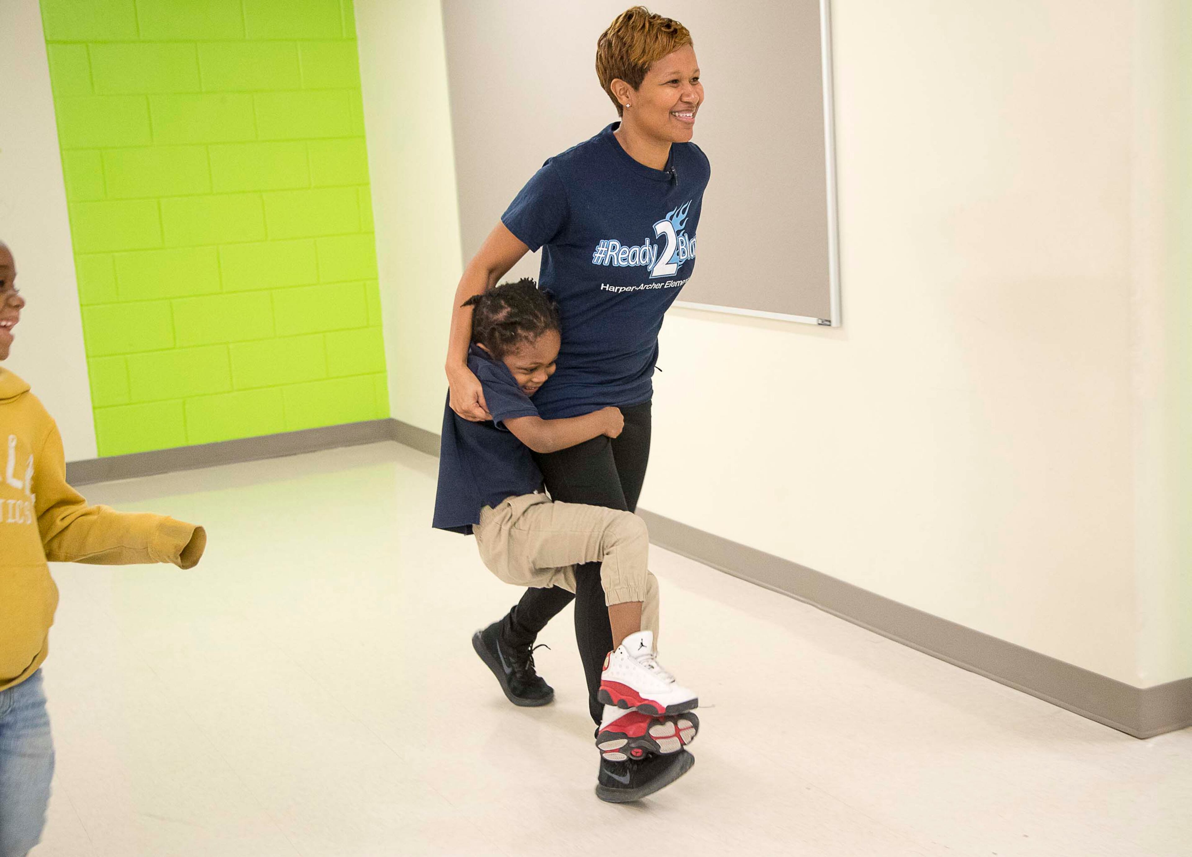 Harper-Archer Elementary School kindergartner Major Thomspon holds onto the leg of the school's dance teacher, Lisa Perrymond, as they make their way to the dance studio for their class, Tuesday, January 28, 2020. Perrymond sees her students once a week for a 45 minute class. (ALYSSA POINTER/ALYSSA.POINTER@AJC.COM)