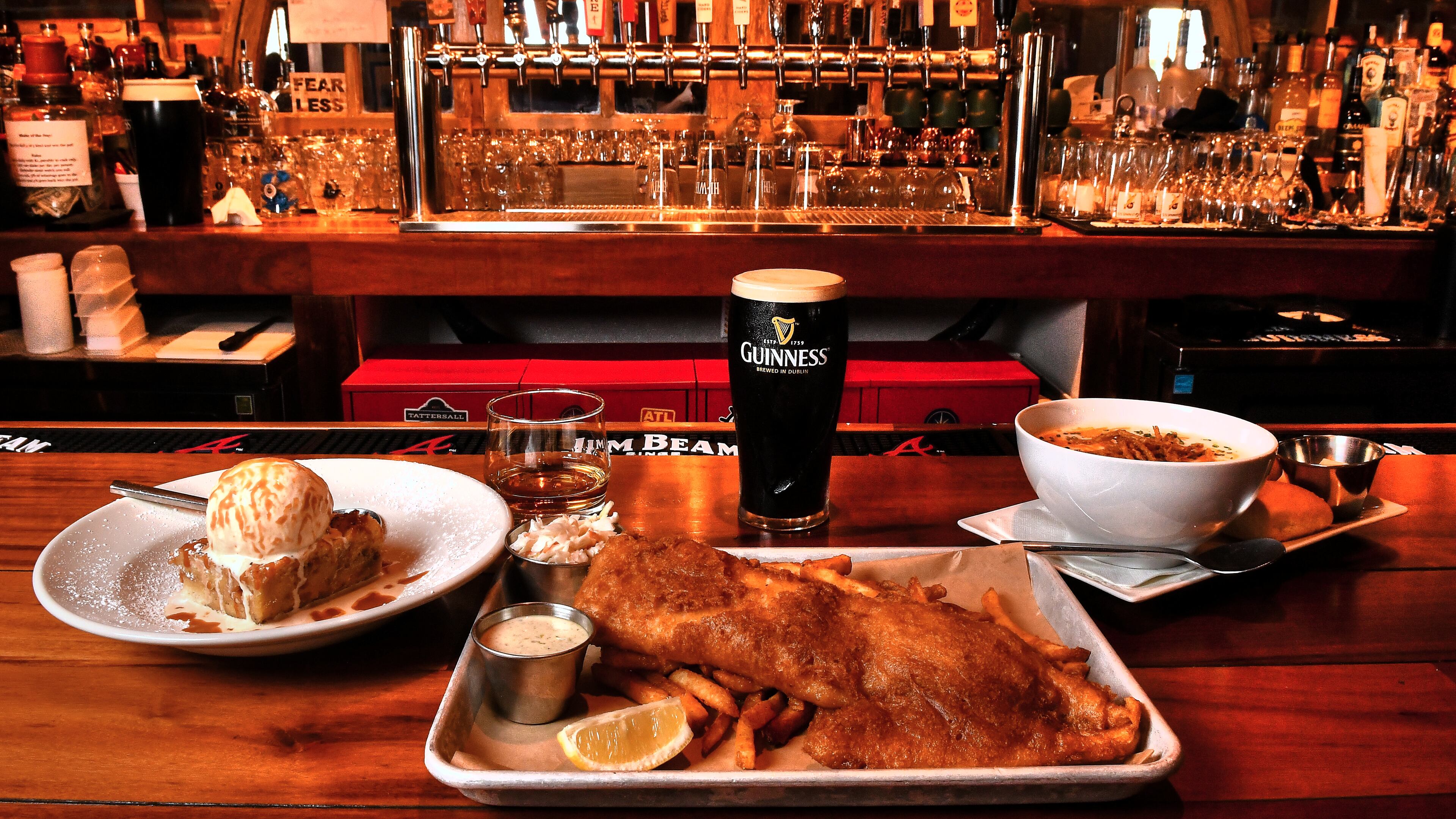 Give your St. Patrick's Day meal the feel of an Irish pub like Wheelhouse Craft Pub and Kitchen in Decatur. Shown here are (from left) Irish Bread Pudding (with Slane Irish Whiskey), Ale Battered Fried Fish (with a Guinness Stout), and Leek and Potato Soup. (Styling by Ian Macken / Chris Hunt for the AJC)