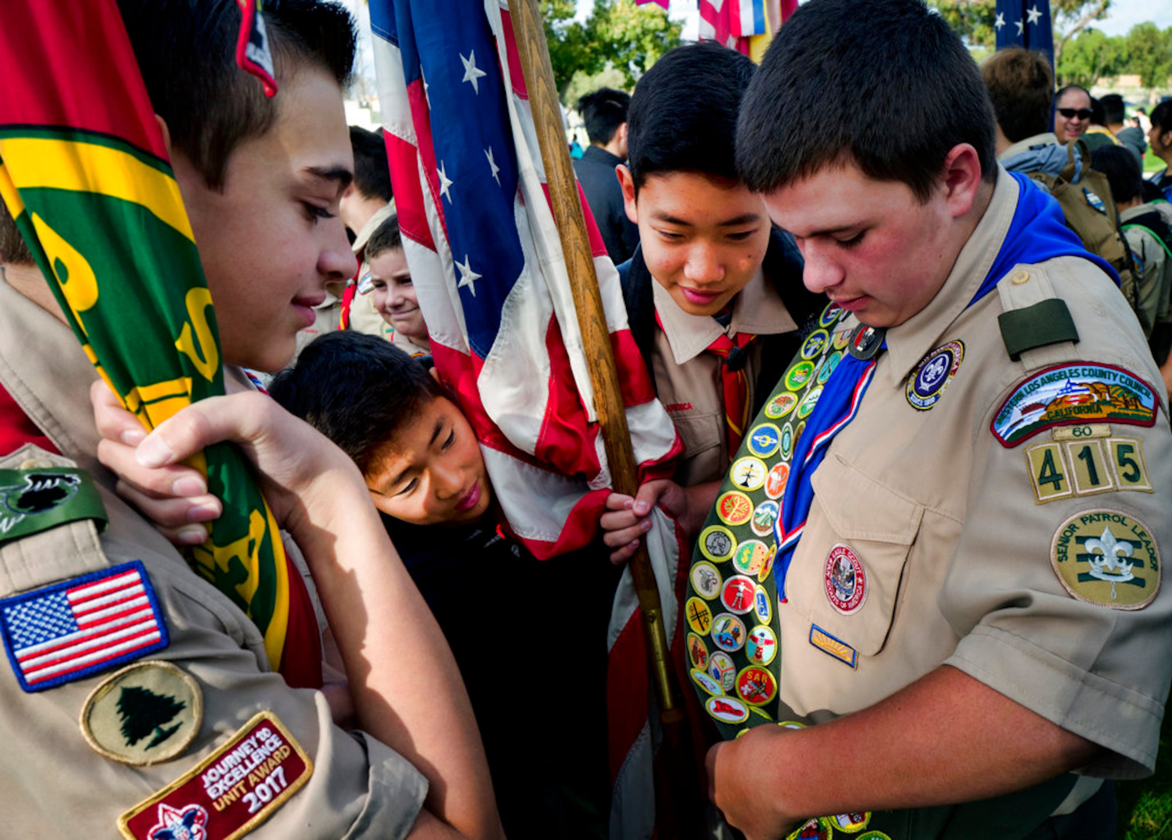 Boy Scouts and Girl Scouts walk between grave stones after helping place flags at the Los Angeles National Cemetery on Saturday, May 26, 2018. Thousands of scouts have placed American flags on the graves of veterans in a ceremony ahead of Memorial Day. More than 6,000 children participated in the event. Each uniformed scout placed a flag in the ground by each grave and saluted. Organizers say nearly 90,000 flags were placed in tribute. (AP Photo/Richard Vogel)