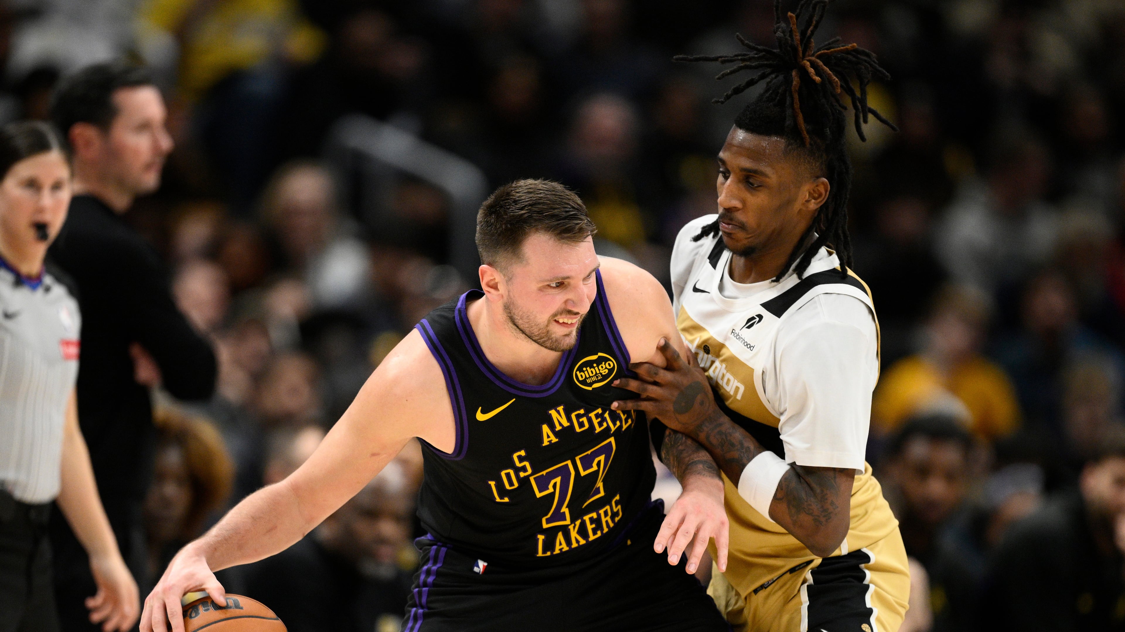Los Angeles Lakers guard Luka Doncic (77) dribbles against Washington Wizards guard Jamir Watkins, right, during the first half of an NBA basketball game, Friday, Jan. 30, 2026, in Washington. (AP Photo/Nick Wass)