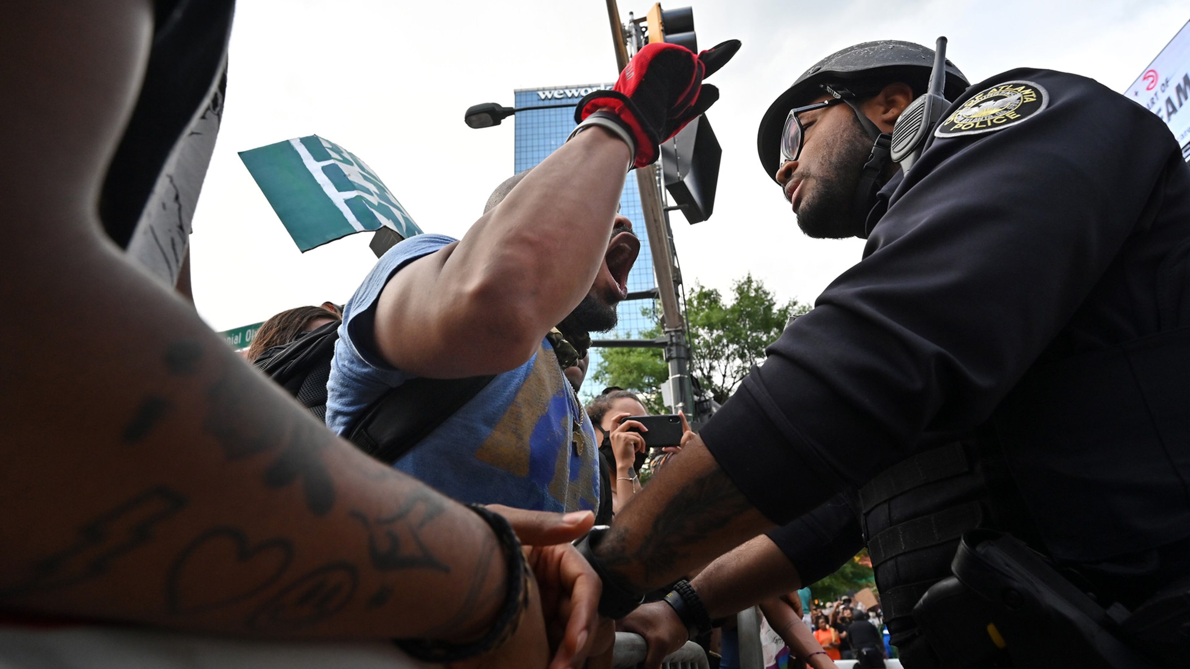 June 4, 2020 Atlanta - Atlanta Police Department A. Thigpen (right) listens as a protestor shouts out during the seventh straight day of protest against police brutality and racism outside CNN Center near Centennial Olympic Park on Thursday, June 4, 2020. For the seventh straight day, metro Atlanta residents are gathering for a series of protests denouncing racism and police brutality and demanding change. Sparked by the deaths of George Floyd in Minneapolis, Ahmaud Arbery in Brunswick and Breonna Taylor in Louisville, demonstrations have filled the streets of downtown Atlanta since Friday. WednesdayâÃôs protests ended largely peacefully after the cityâÃôs curfew hit. A 9 p.m. curfew is in effect in Atlanta again Thursday. (Hyosub Shin / Hyosub.Shin@ajc.com)