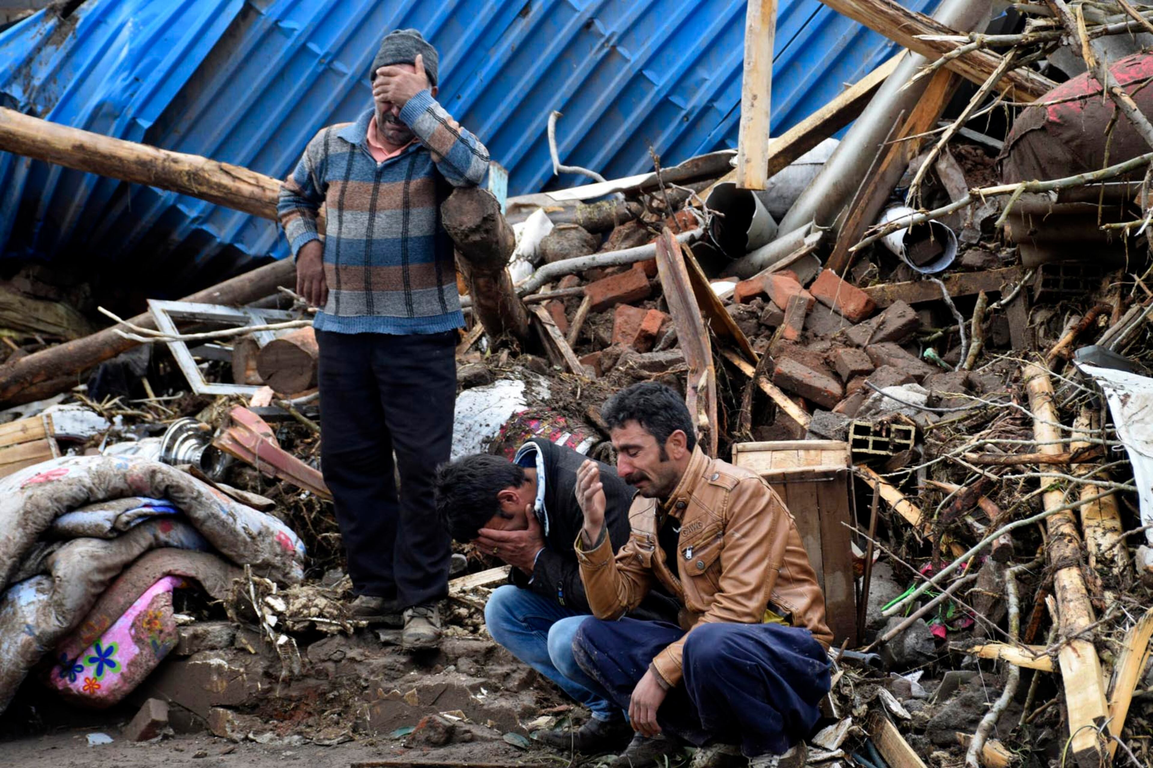 In this picture released by Islamic Republic News Agency, IRNA, villagers weep while some members of their family missing after flash floods triggered by heavy rains in Chenar village near city of Ajabshir in northwestern Iran, Saturday, April 15, 2017. The death toll in flash floods in Iran's northwestern province of eastern Azarbaijan jumped to 30 as rescue teams continue to discover bodies, state TV reported Saturday. The report said that there are at least seven people still missing in the cities of Ajabshir and Azarshahr. (AP Photo/IRNA, Shahram Naemvand)