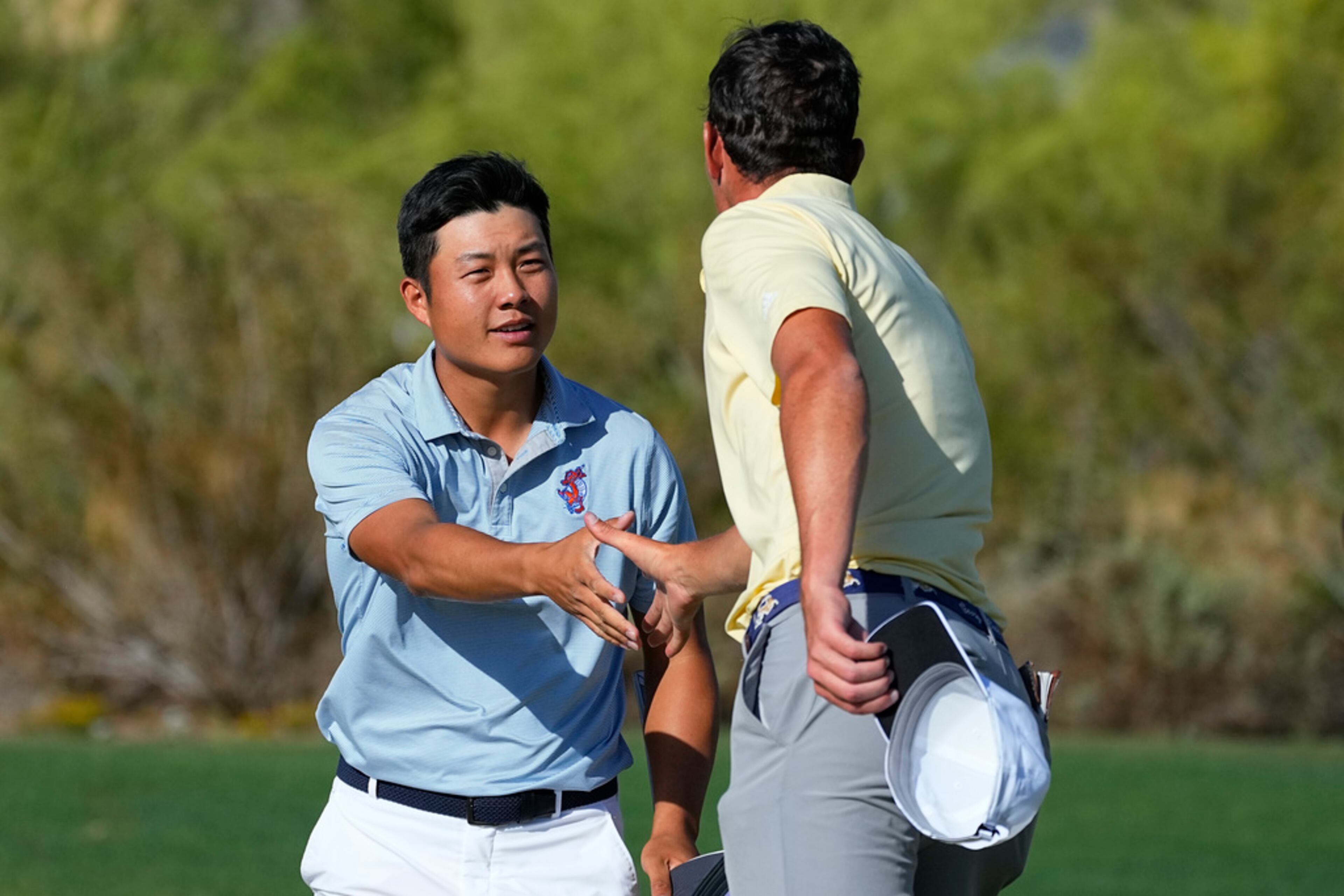 Florida golfer Yuxin Lin shakes hands with Georgia Tech golfer Christo Lamprecht, right, after winning his match during the final round of the NCAA college men's match play golf championship, Wednesday, May 31, 2023, in Scottsdale, Ariz. (AP Photo/Matt York)