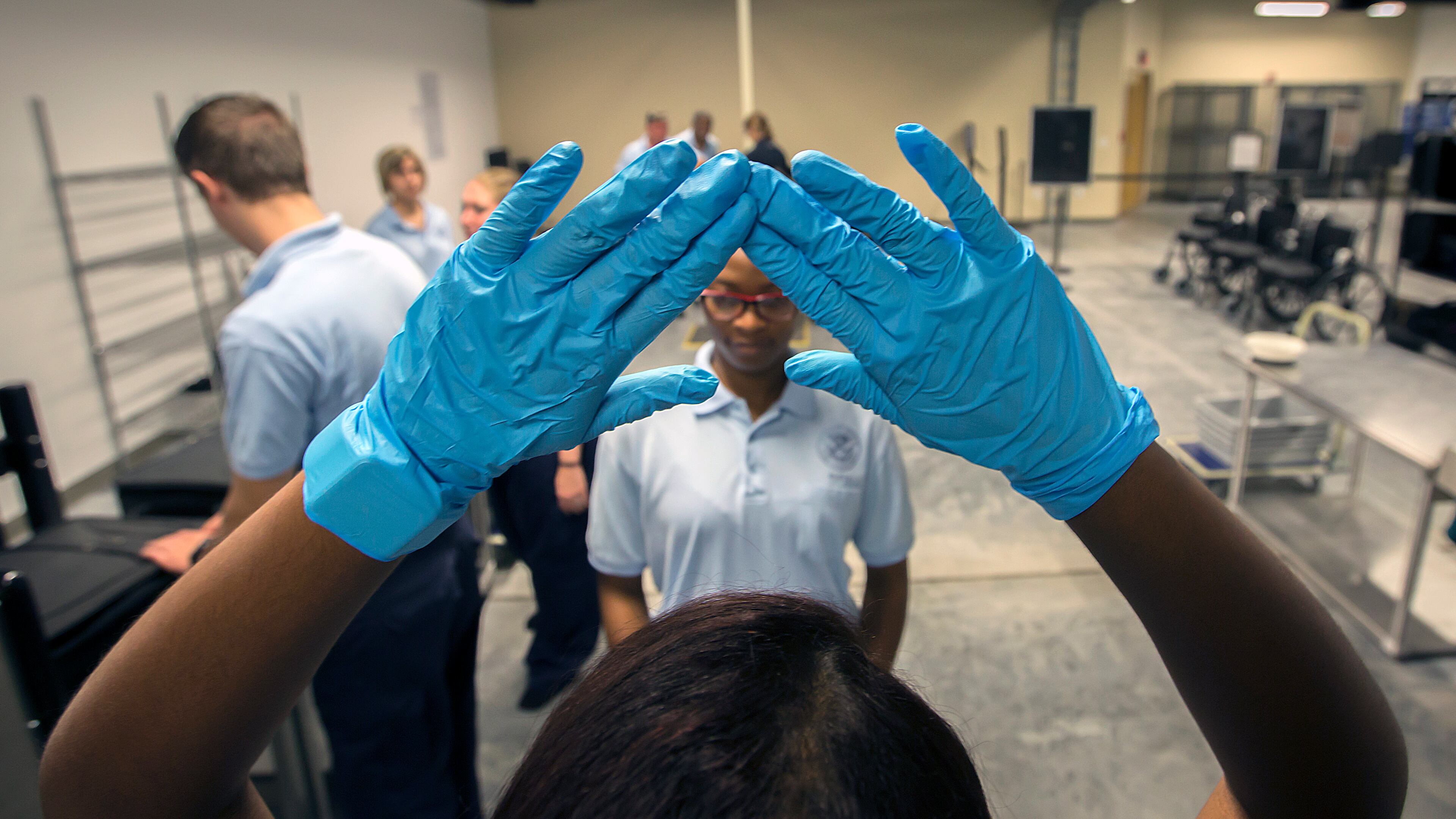 BRUNSWICK, GA - JULY 27, 2016: Transportation Security Administration Academy student Vivianette Calazan, left, of Puerto Rico trains with other student at a mock screening classroom at the new TSA Academy in Brunswick, Ga.