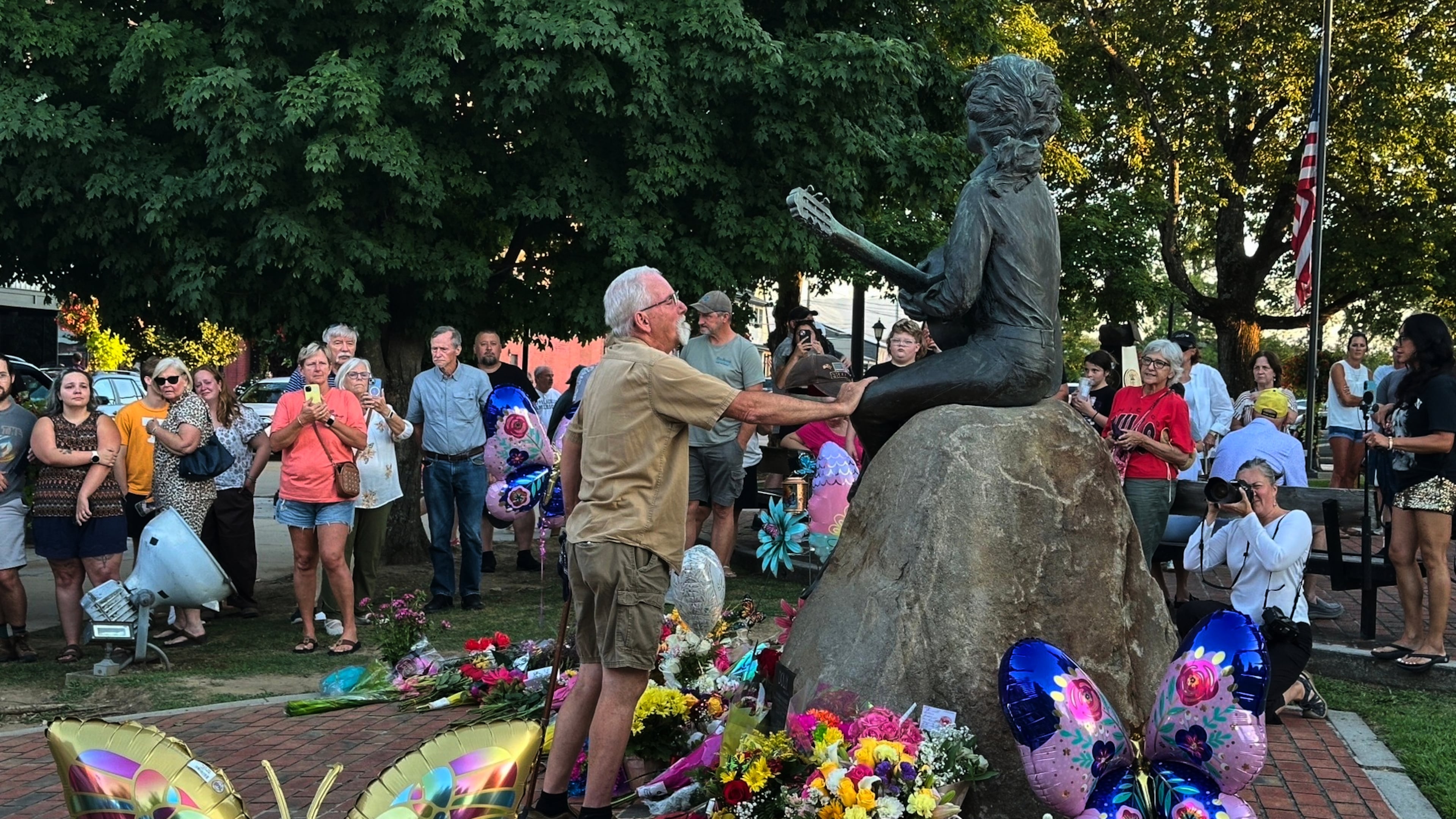 James A. Gambrell, a former chef at Dollywood, touches the Dolly Parton statue in downtown Sevierville, Tenn., on Tuesday, Aug. 25, 2026. (AP Photo/Dylan Lovan)
