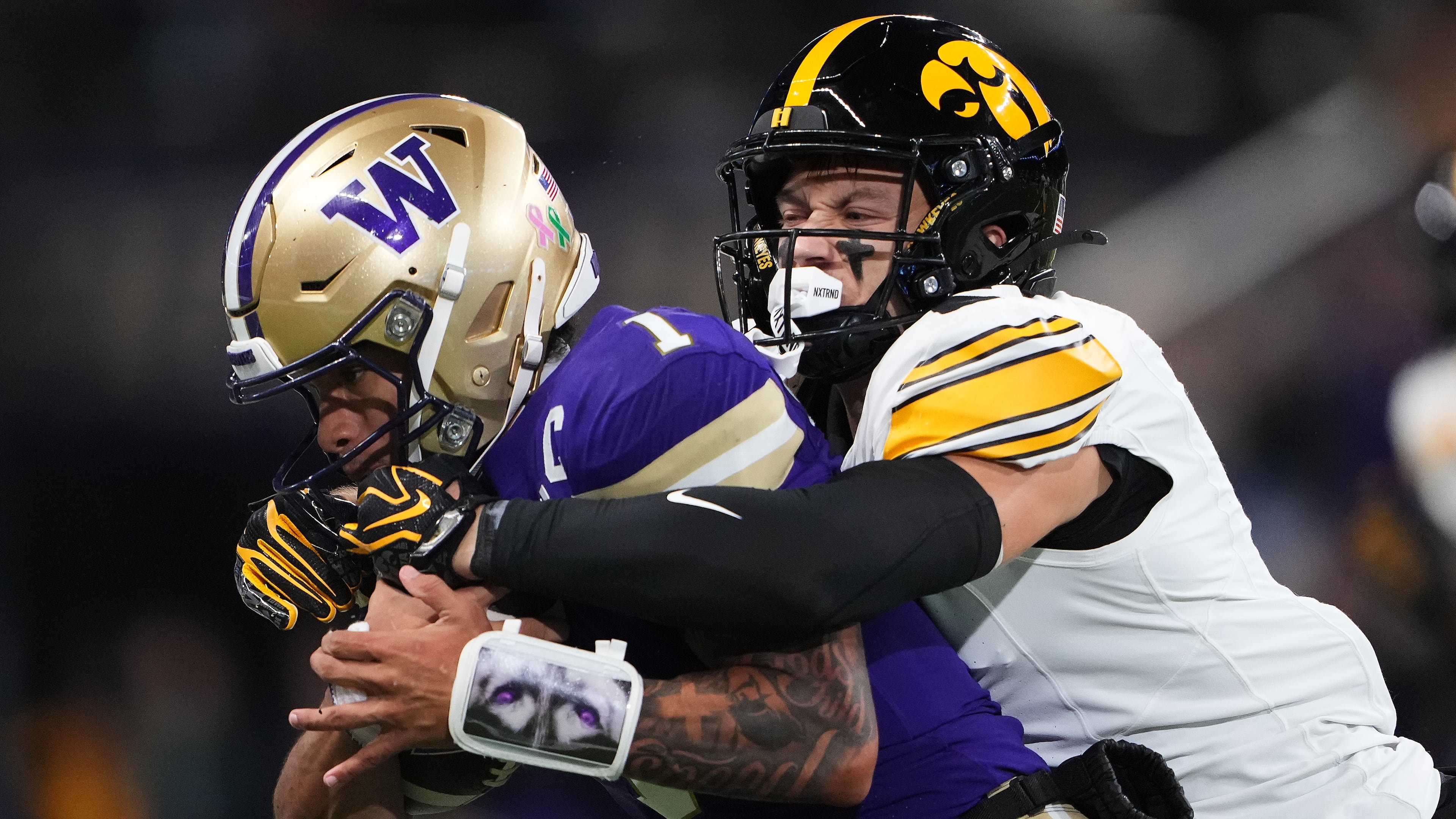 Iowa defensive back Zach Lutmer, right, tackled Washington quarterback Demond Williams Jr. during the first half of an NCAA college football game, Friday, Oct. 9, 2026, in Seattle. (AP Photo/Lindsey Wasson)