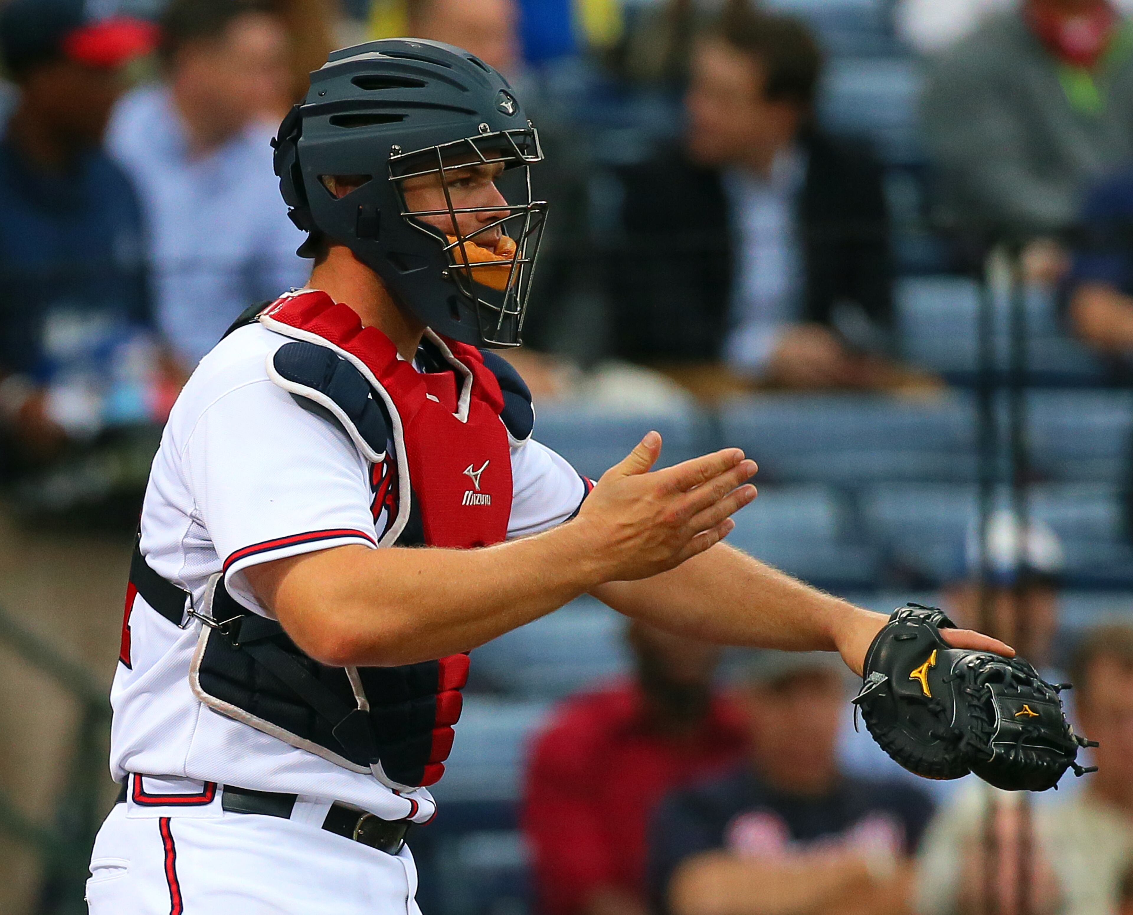 Braves catcher Evan Gattis gives signals to pitcher Kris Medlen after falling behind 3-0 to the Nationals during the second inning.