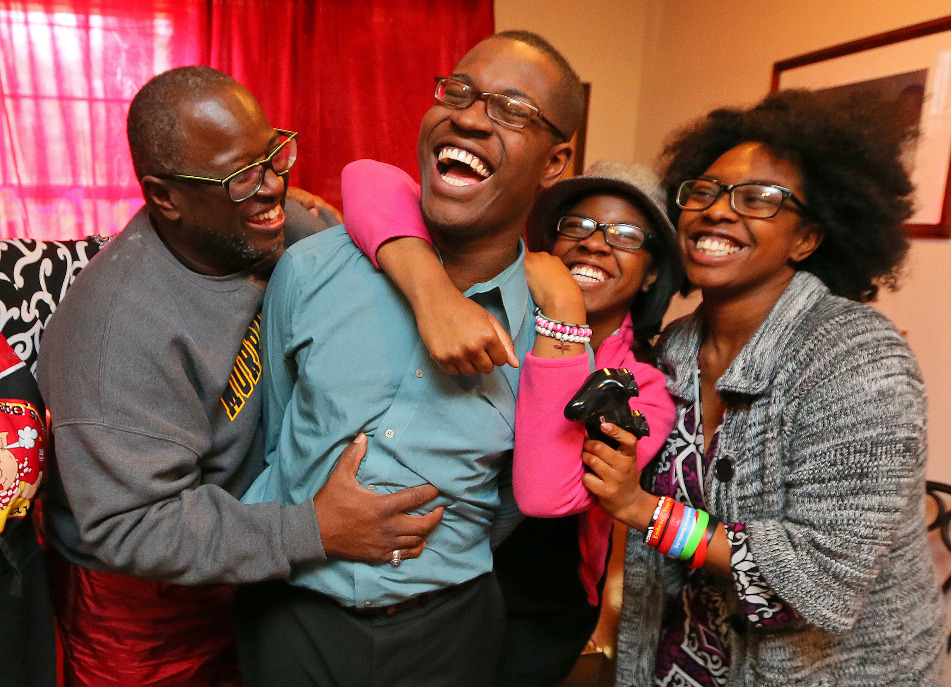 Omar, now 20, gets a ribbing from his father, Garry, and sisters, Devyne (in hat), 14, and Eryn, 16, after winning a video game. "We are very proud of Omar," said his father. "I always told Omar if you believe in yourself, the sky is the limit."