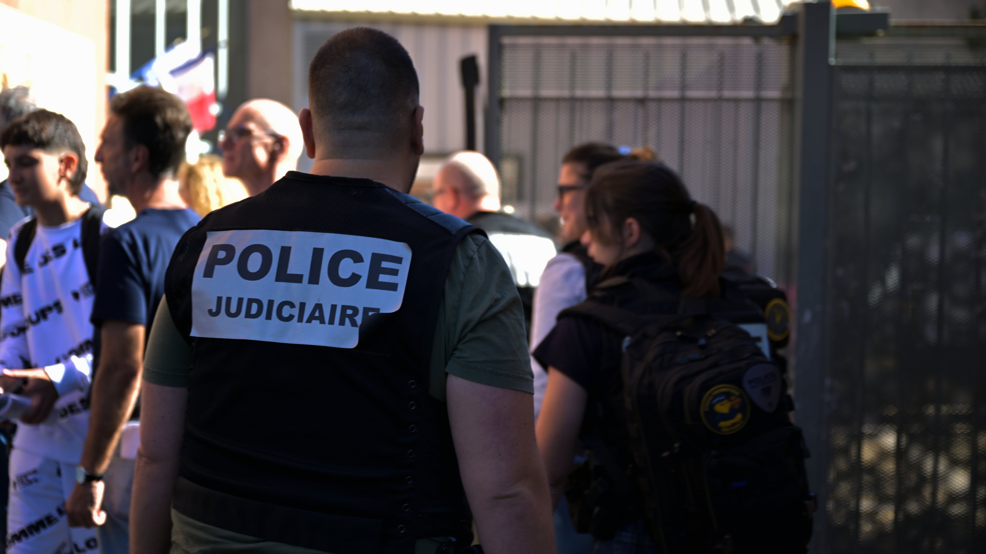 A police officer stands in front the Joseph Lakanal middle school after police have detained a 14-year-old pupil suspected in a rare school shooting, in Aubagne, France, Monday Oct. 12, 2026. (AP Photo/Philippe Magoni)