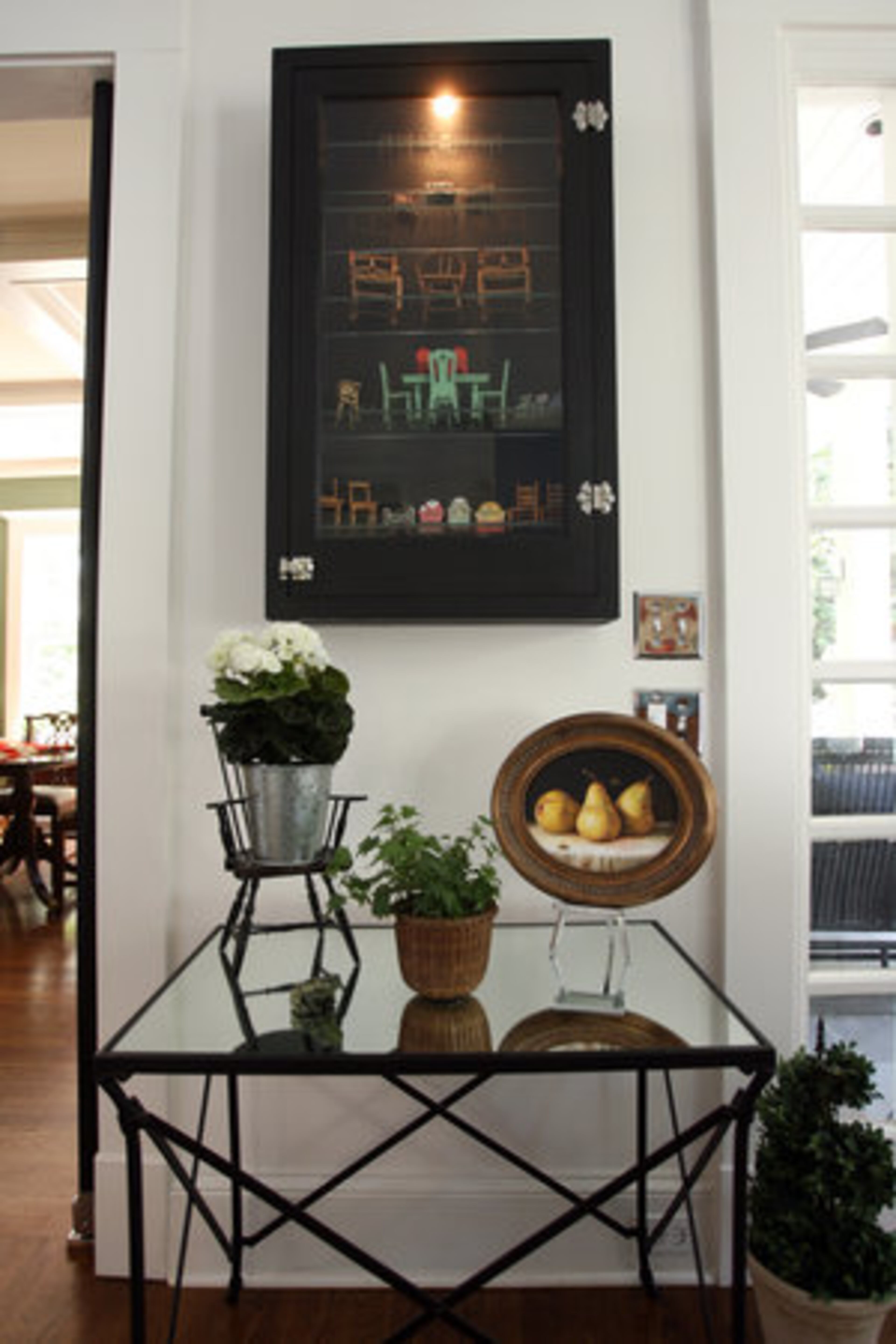 Susan Gibbs displays her large collection of miniature chairs in an old apothecary cabinet in her kitchen.