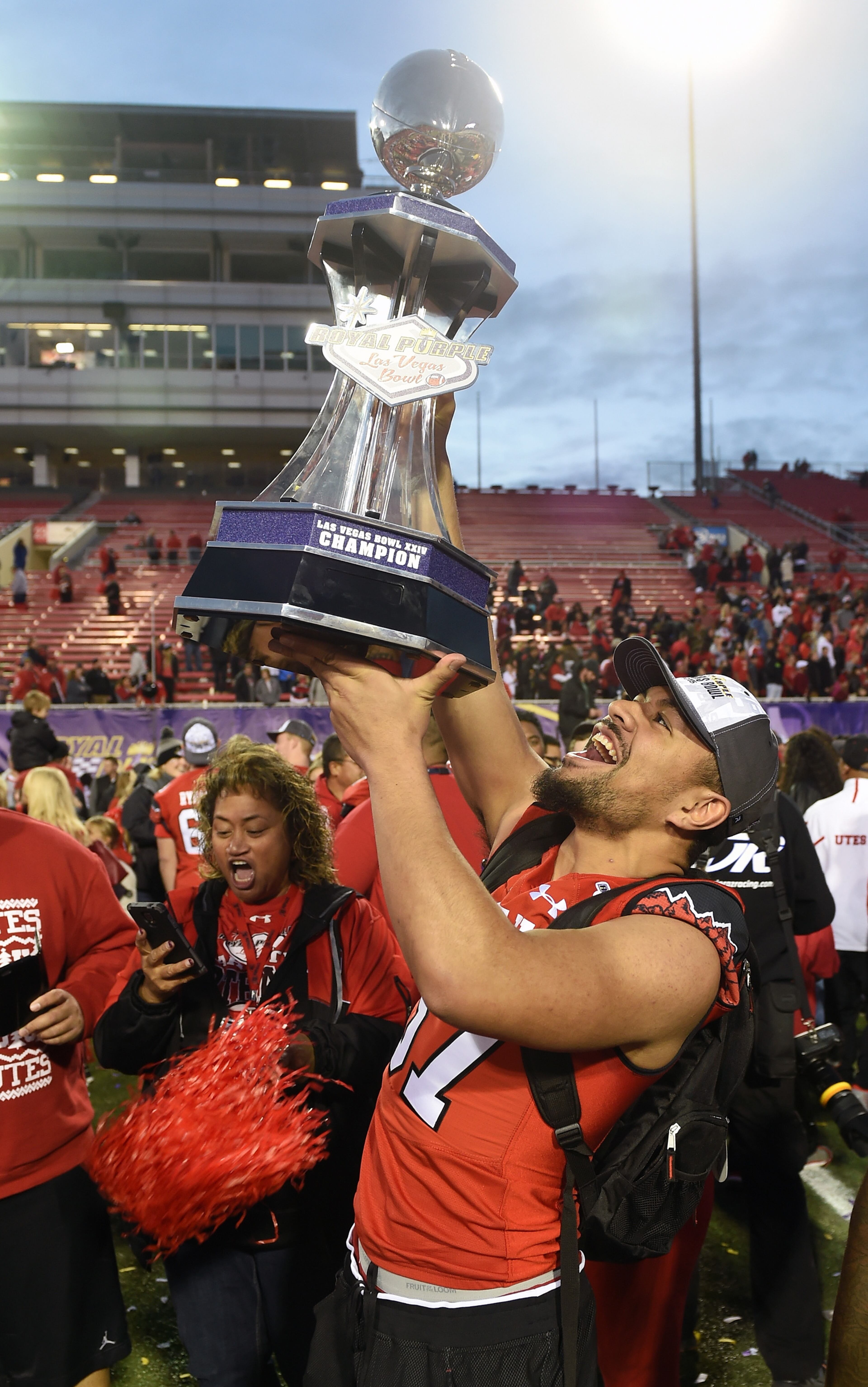 LAS VEGAS, NV - DECEMBER 19: Linebacker Justin Tatola #57 of the Utah Utes holds up the championship trophy after the Utes defeated the Brigham Young Cougars 35-28 to win the Royal Purple Las Vegas Bowl at Sam Boyd Stadium on December 19, 2015 in Las Vegas, Nevada. (Photo by Ethan Miller/Getty Images)