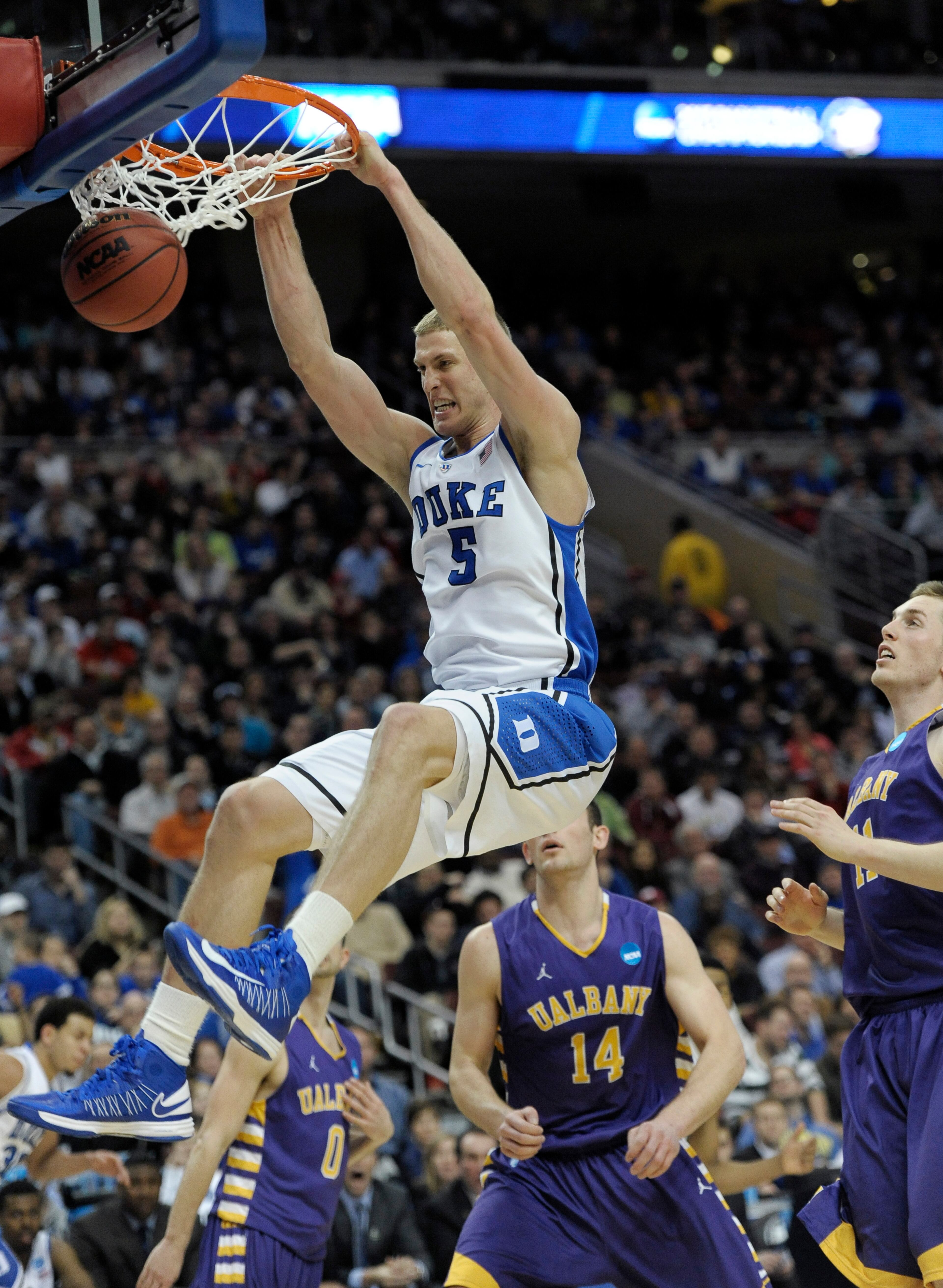 Duke's Mason Plumlee (5) dunks the ball past Albany's Luke Devlin (11), Sam Rowley (14) and Jacob Iati (0) during the second half of a second-round game of the NCAA college basketball tournament on March 22, 2013.