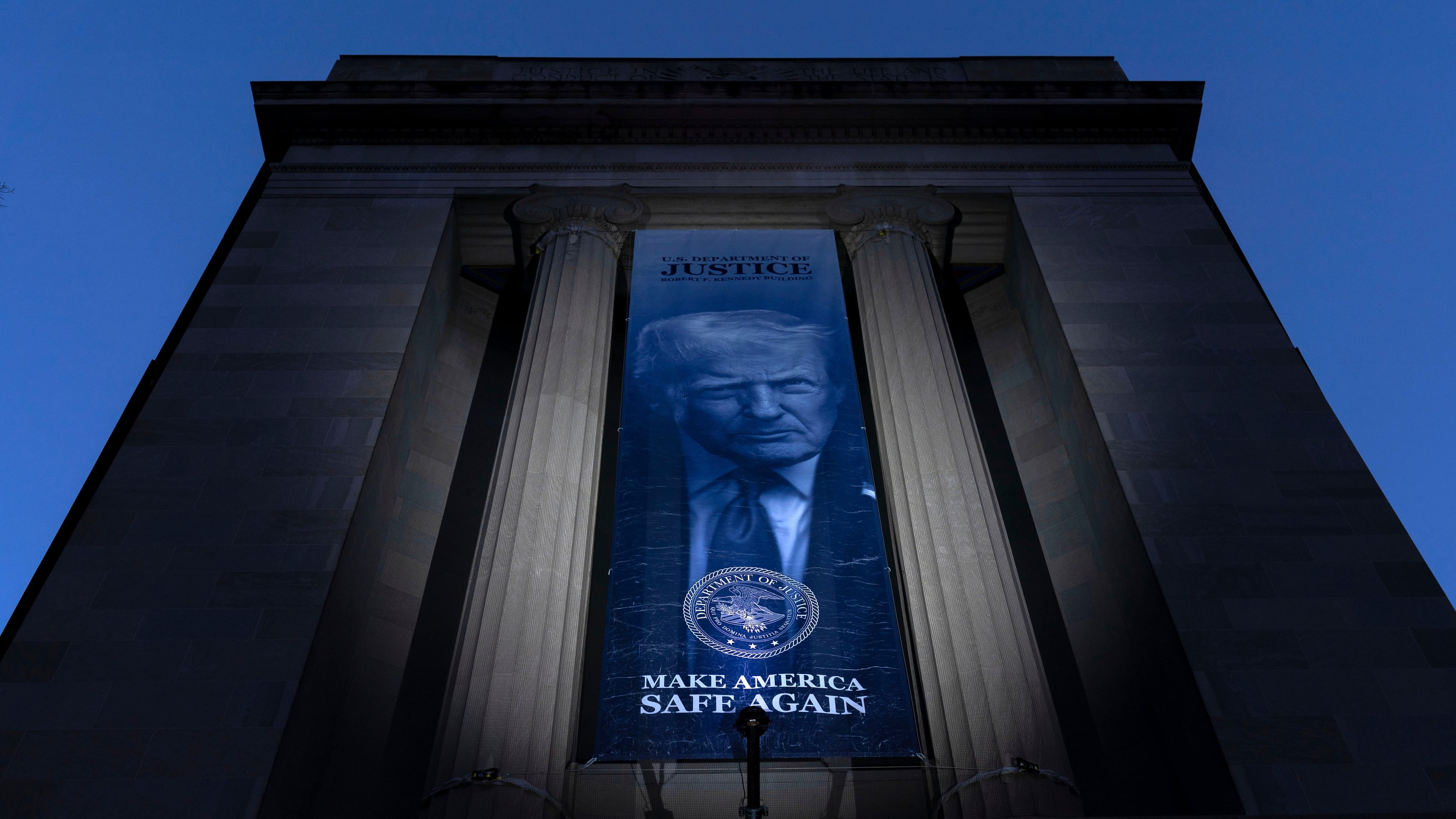 FILE - A banner with a portrait of President Donald Trump is hung from the Department of Justice, March 7, 2026, in Washington. (AP Photo/Jose Luis Magana)