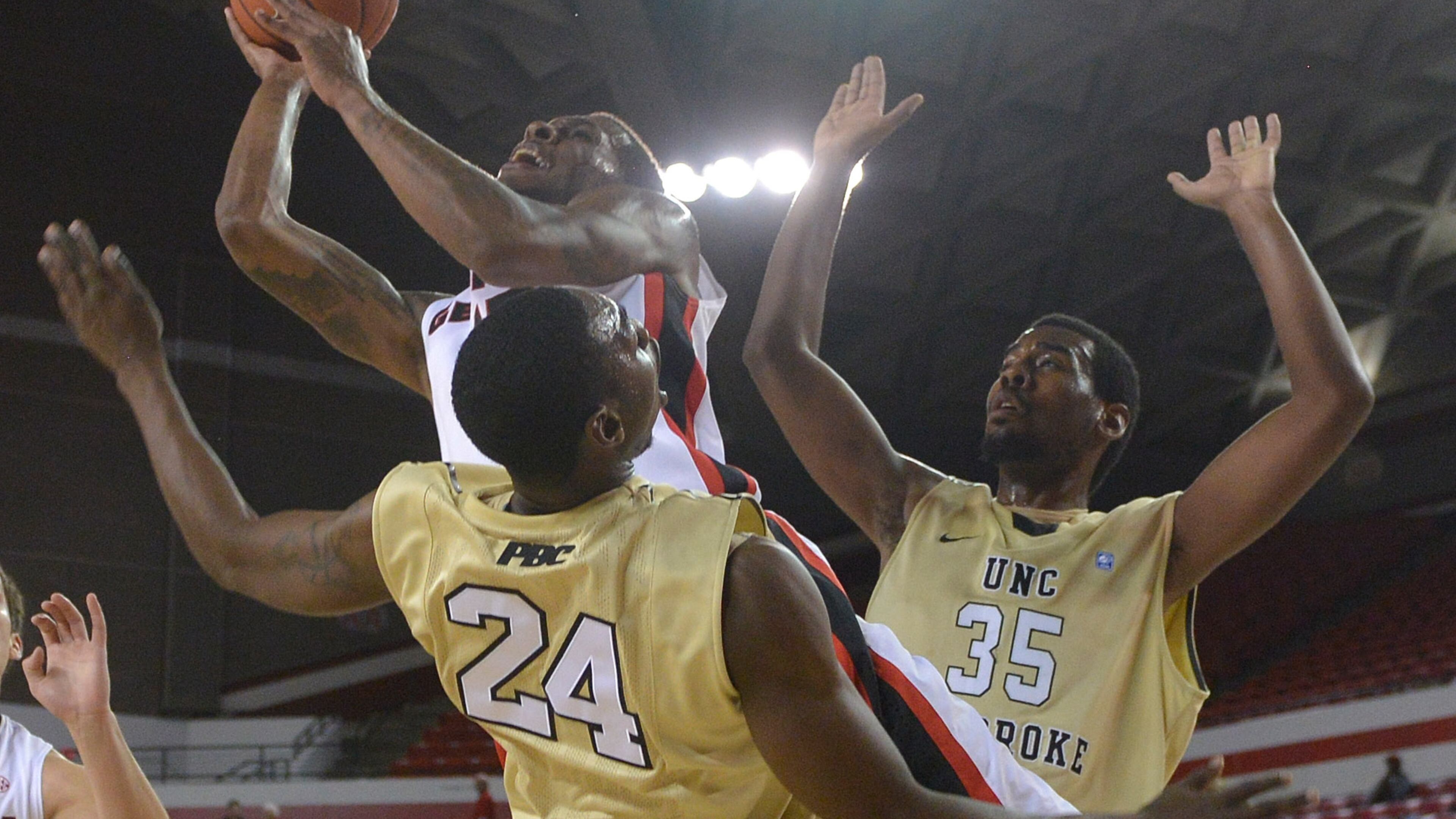 Georgia forward Donte' Williams (15) charges through UNC-Pembroke guard Jihad Wright (24) to put up a shot during the first half of an NCAA exhibition college basketball game Monday, Nov. 4, 2013, in Athens, Ga. (AP Photo/Richard Hamm/Athens Banner-Herald)