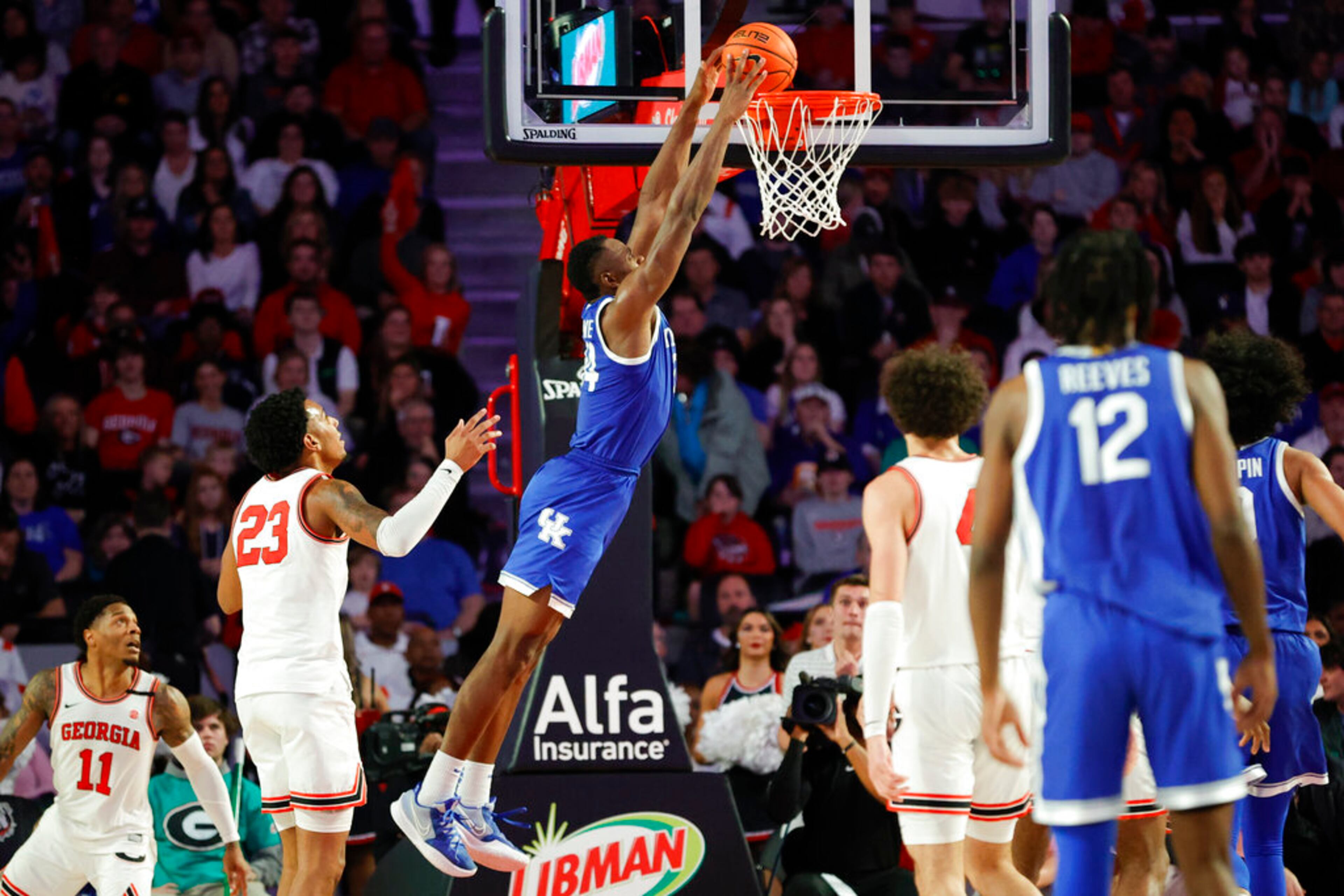 Kentucky forward Oscar Tshiebwe, center, dunks the ball near Georgia center Braelen Bridges, left, during the second half of an NCAA college basketball game, Saturday, Feb. 11, 2023, in Athens, Ga. (AP Photo/Alex Slitz)