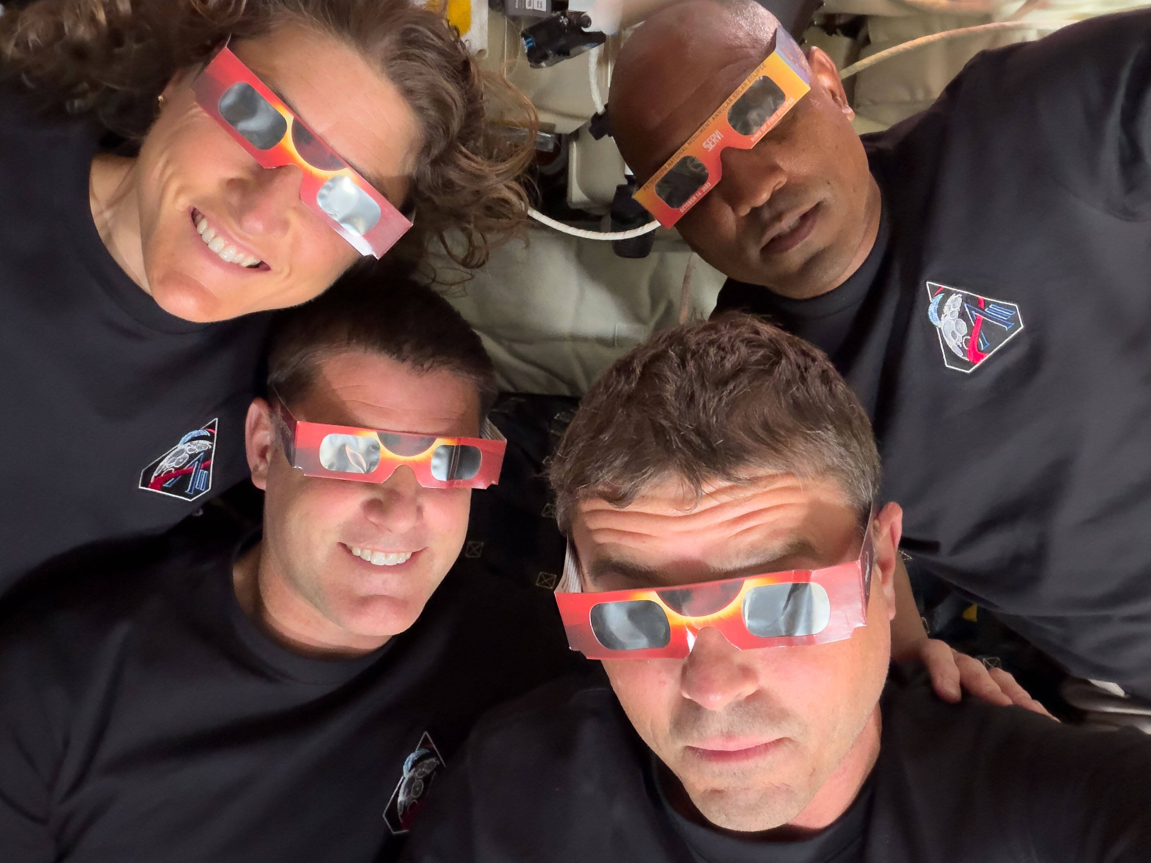 The Artemis II crew (counterclockwise from top left), mission specialist Christina Koch, mission specialist Jeremy Hansen, commander Reid Wiseman and pilot Victor Glover pose with eclipse viewers during a lunar flyby in April. (NASA via AP)