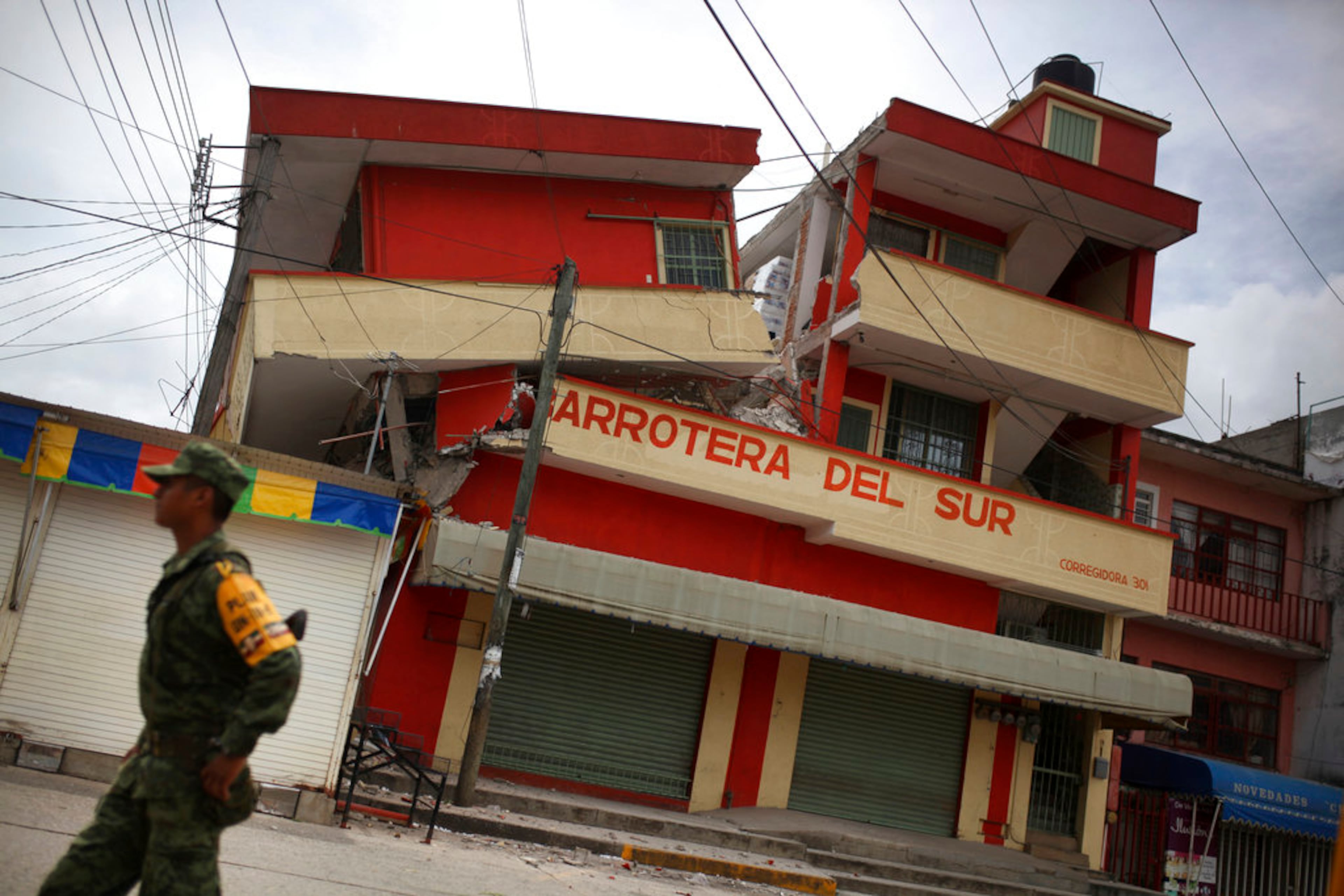 A soldier walks by a partially collapsed structure in the town of Matias Romero, Oaxaca state, Mexico, Friday, Sept. 8, 2017. One of the most powerful earthquakes ever recorded in Mexico struck off the country's southern coast, toppling hundreds of buildings, triggering tsunami evacuations and sending panicked people fleeing into the streets in the middle of the night. At least 35 people were reported killed.(AP Photo/Felix Marquez)
