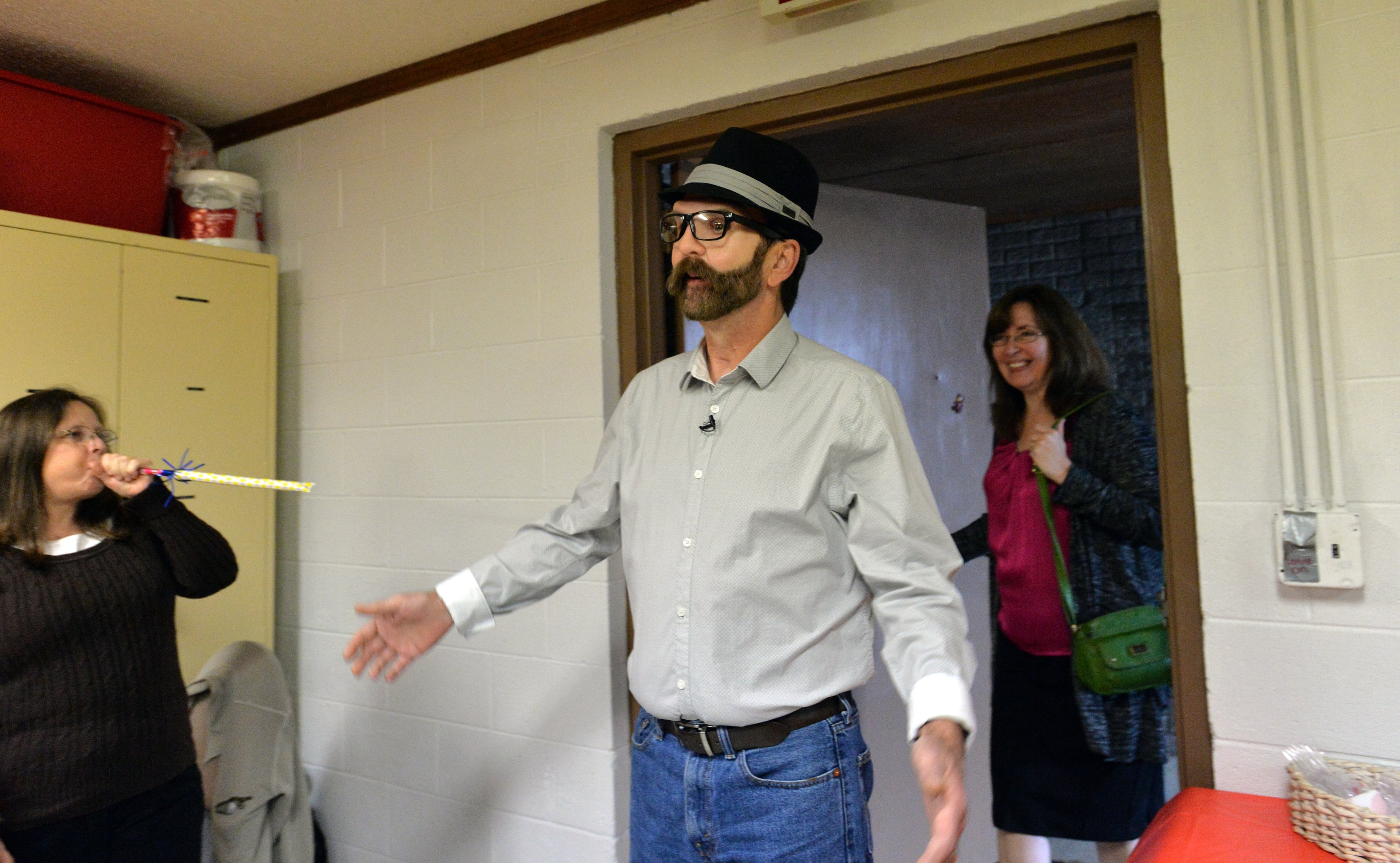 Donnie Fritts, who has had a new face made to replace his face that a rare form of cancer has destroyed, walks into his surprise party as his wife Sharon Fritts (right) follows at The Barrett Road Church of God in Calhoun on Saturday, November 16, 2013. Donnie Fritts was supposed to die, but the Canton resident decided he would fight, then fight some more, to keep hold on the life he shares with his wife, Sharon. Diagnosed in 2005 with a rare form of cancer, he lost most of his face to the creeping disease. It created a hole the size of a baseball in the middle of his face. Now, he is about to get a new face -- new nose, new eyebrows, a plastic palate to replace the one cancer took away. "How do you keep on going?" a man asked him recently. Fritts, who is accustomed to such inquiries, merely smiled. "You just got to keep on going, " he said. HYOSUB SHIN / HSHIN@AJC.COM