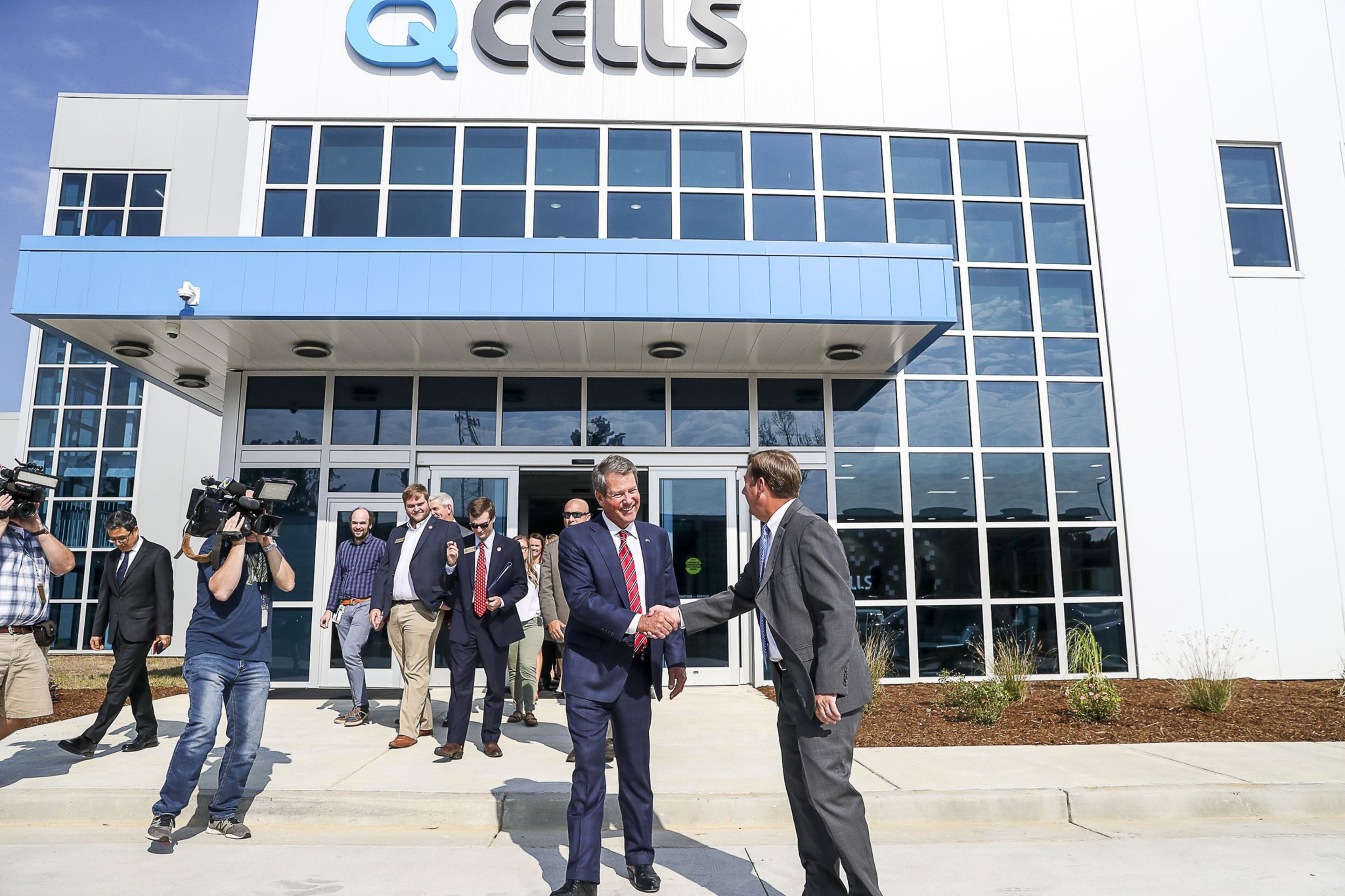 Gov. Brian Kemp is greeted after finishing a tour of the Hanwha Qcells solar manufacturing facility in Dalton. The company recently announced it would expand its production in Georgia.