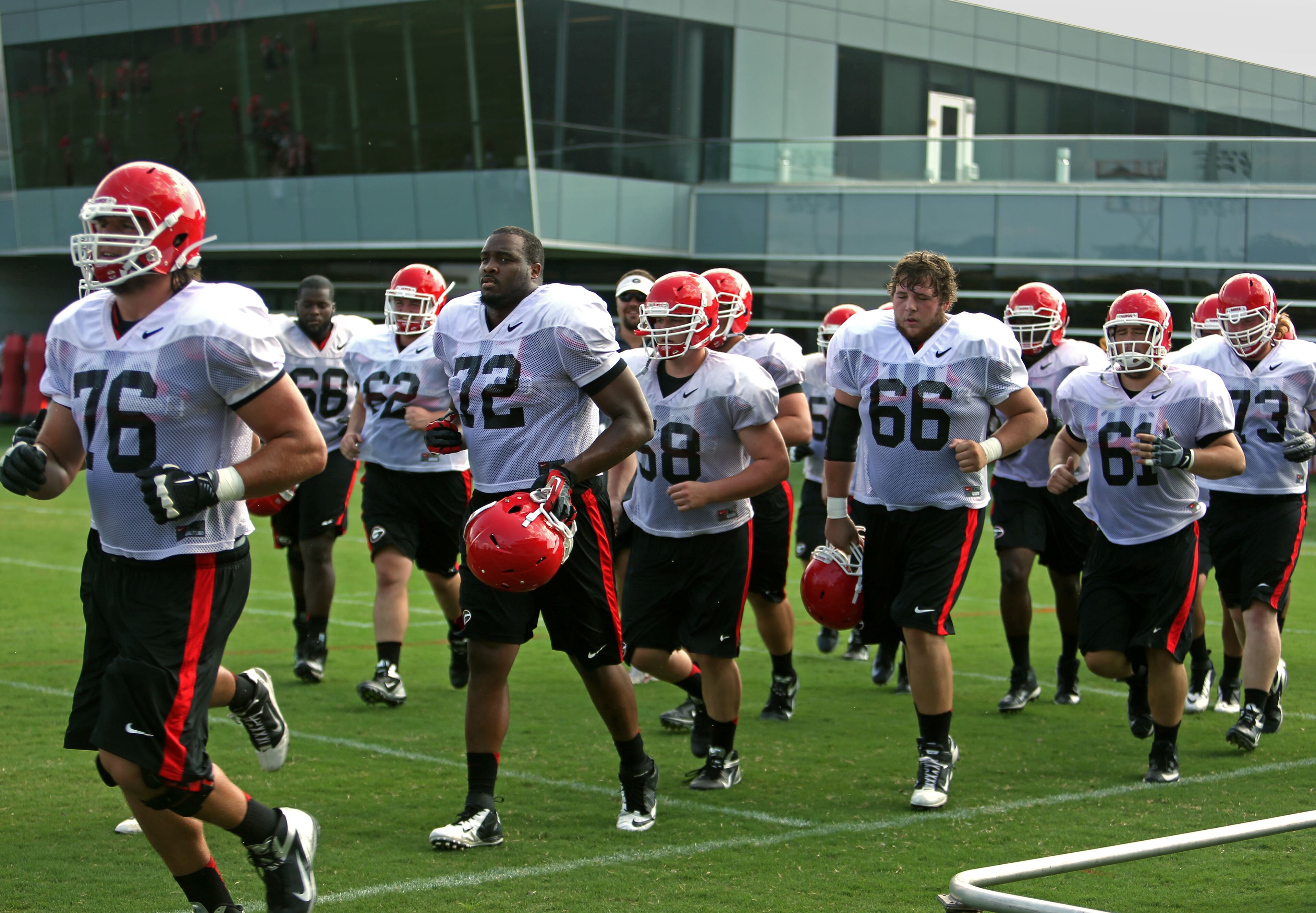 University of Georgia offensive lineman from left to right; Zach DeBell (76) Kenarious Gates (72), Hunter Long (66) and David Andrews (61) jog together for another drill during preseason practice at the University of Georgia Friday afternoon in Athens, Ga., August 23, 2013. JASON GETZ / JGETZ@AJC.COM
