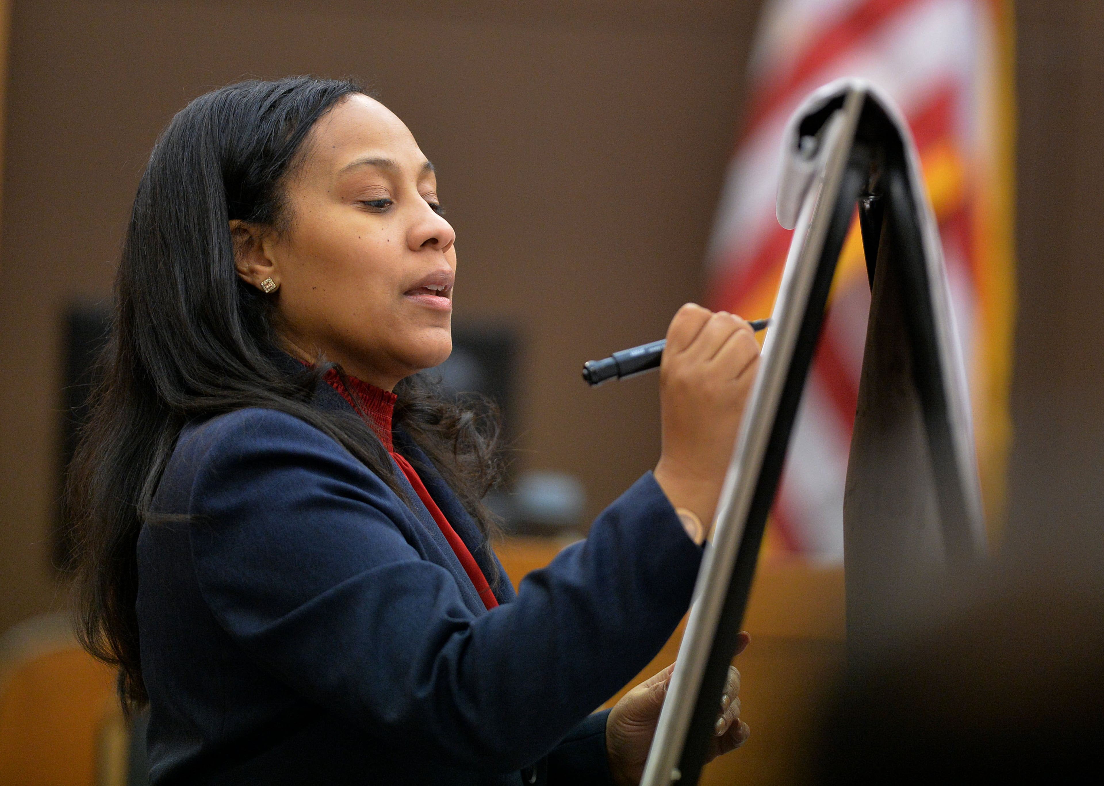 Then-Fulton County Chief Senior Assistant DA Fani Willis takes notes as Tameka Butler-Grant, former APS teacher at Parks Middle and Dobbs Elementary schools, testifies in court in November 2014. KENT D. JOHNSON / KDJOHNSON@AJC.COM