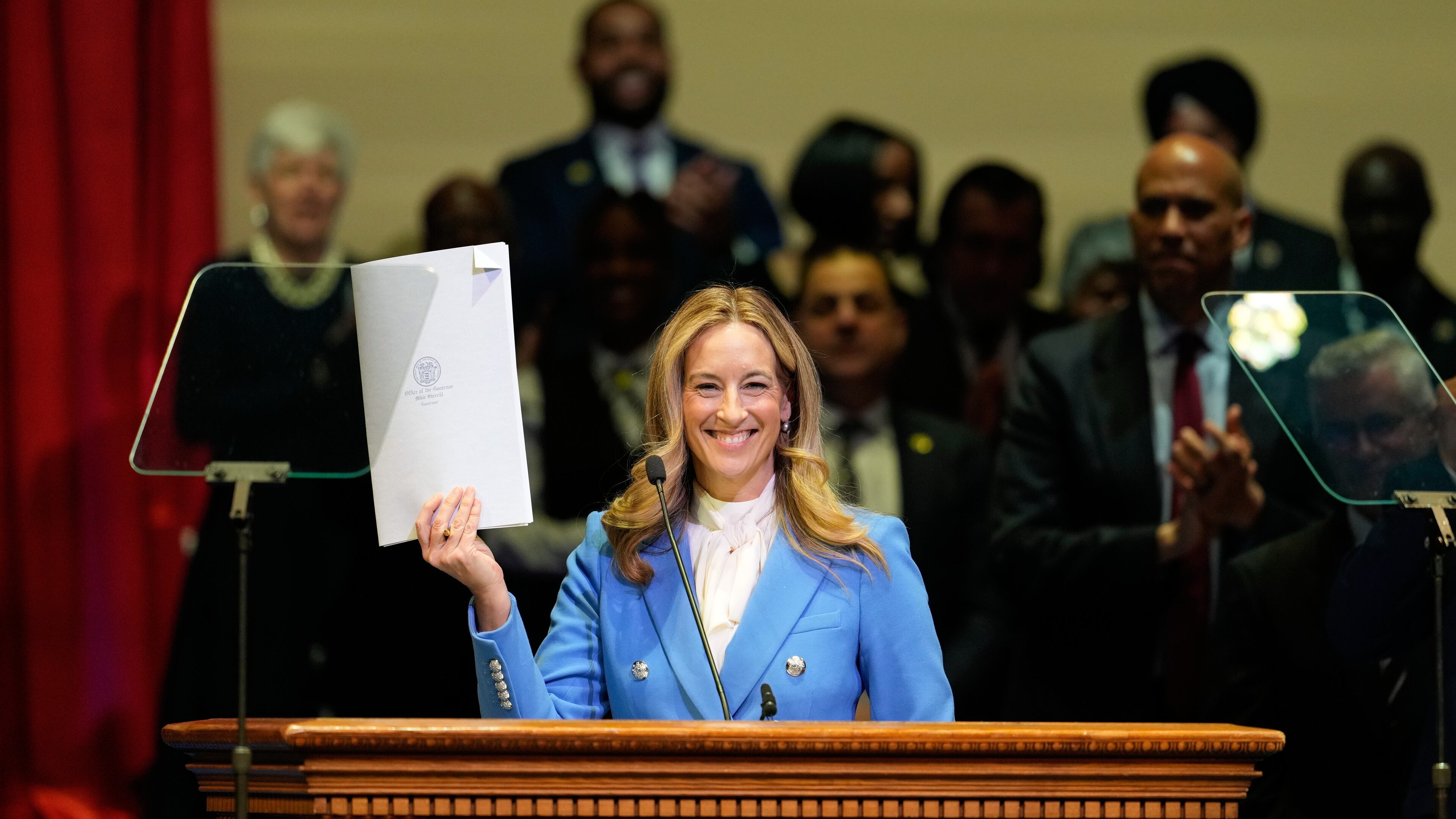 New Jersey Gov. Mikie Sherrill holds up a just signed executive order during her inauguration ceremony in Newark, N.J., Tuesday, Jan. 20, 2026. (AP Photo/Seth Wenig)