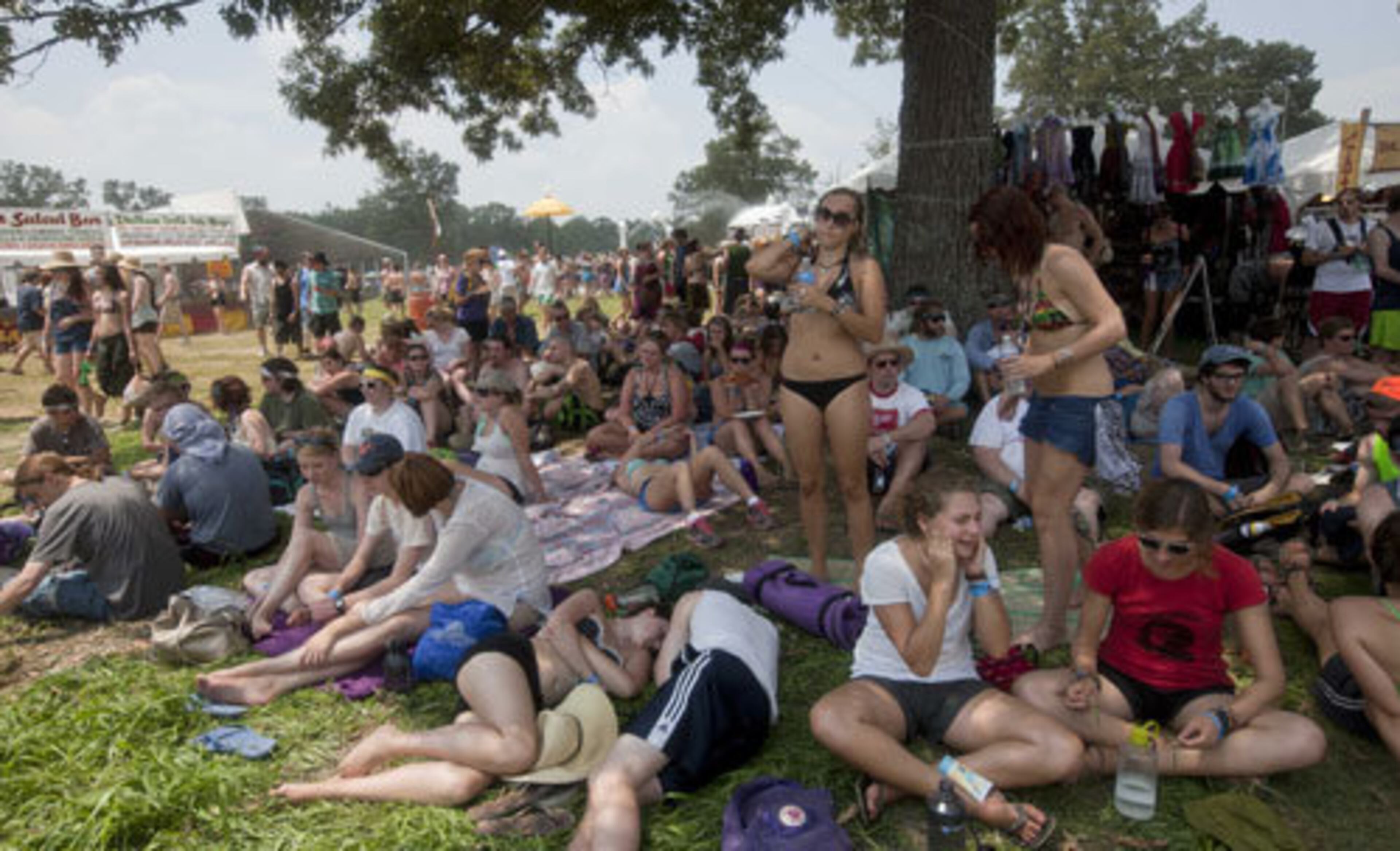 Music lovers sit in the shade as they wait for the music begin on the opening day of Bonnaroo Thursday, June 9.