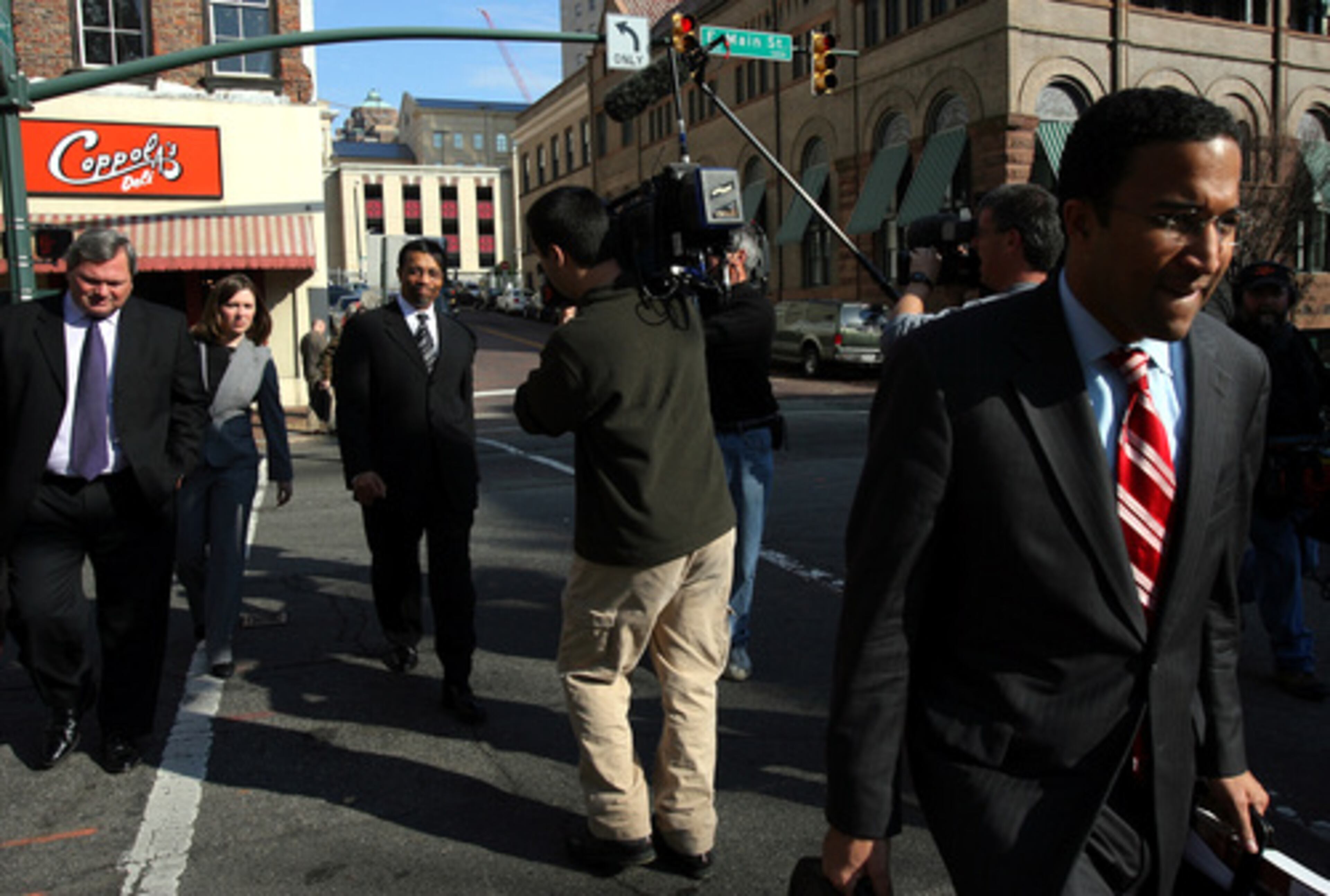 Attorney Billy Martin (center) walks to his car after Michael Vick's sentencing Monday in Richmond, Va.