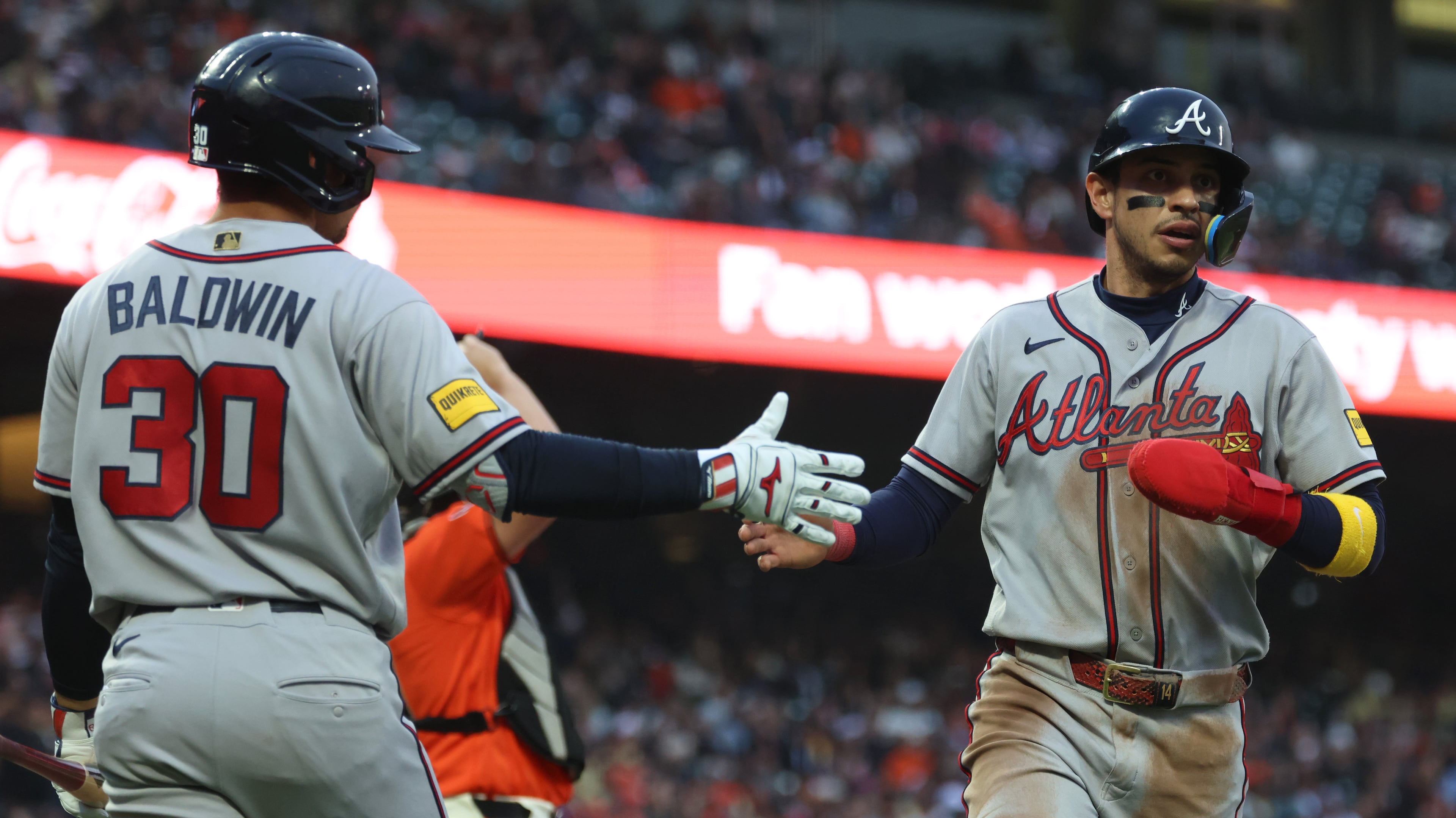 Atlanta Braves' Mauricio Dubón, right, is congratulated by Drake Baldwin (30) after scoring on a single by Ozzie Albies during the third inning of a baseball game against the San Francisco Giants in San Francisco, Friday, June 26, 2026. (AP Photo/Jed Jacobsohn)