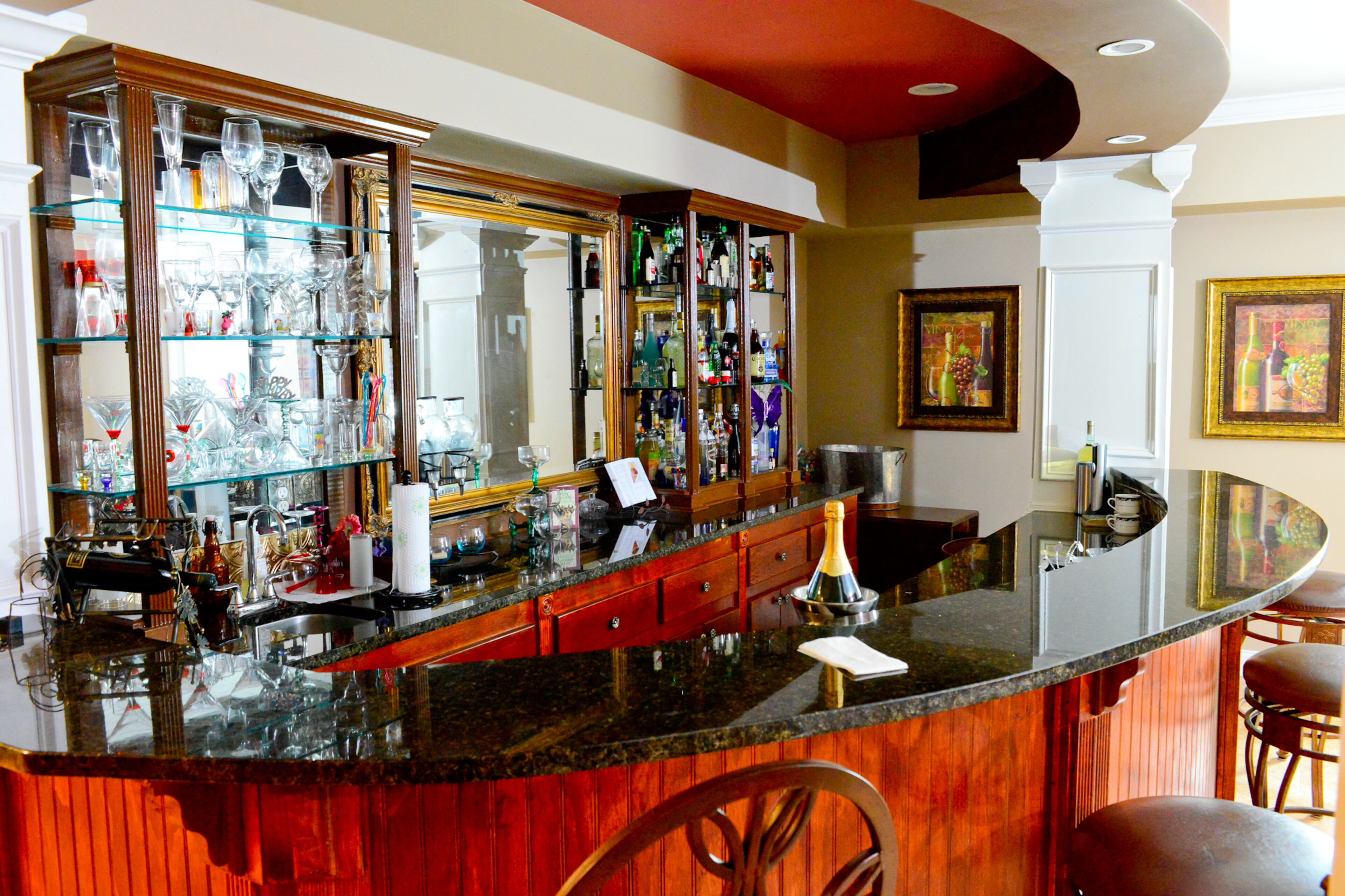 Homeowner Garnell Pace designed and built the bar, giving it a unique curved look. He obtained the cabinets from the Atlanta Salvage Outlet in West Midtown. The granite bar was pieced together from scrap pieces and the mirror was a piece from a previous home.