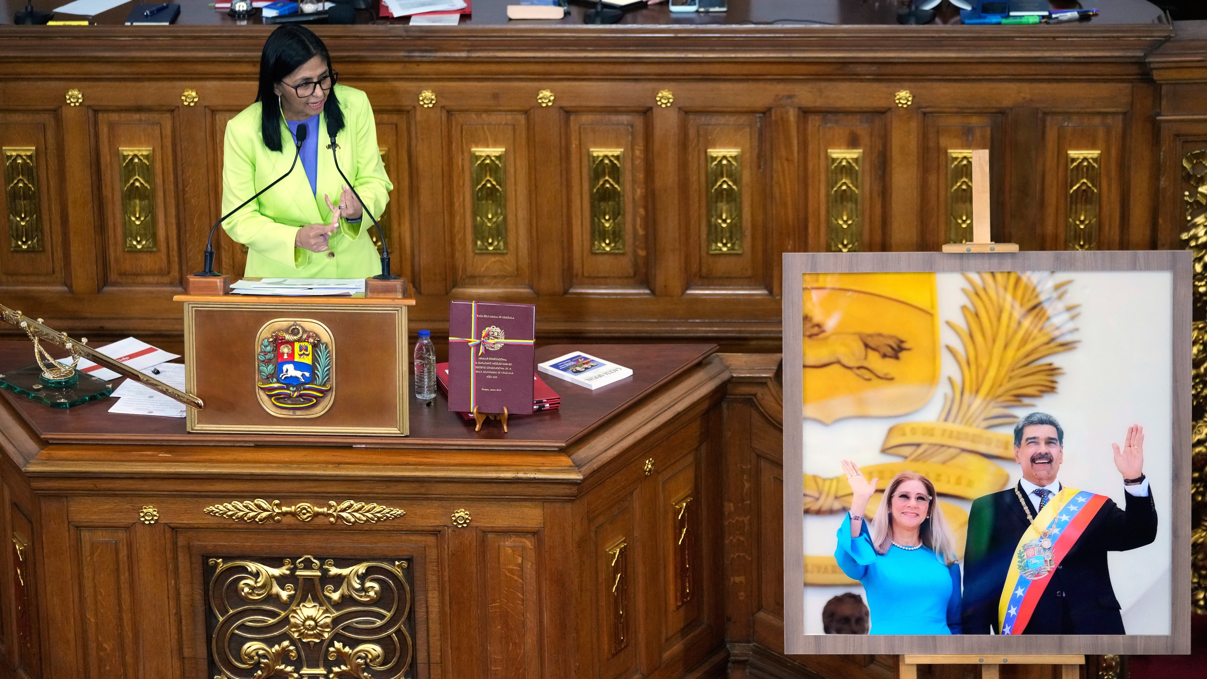 FILE - Venezuela's acting President Delcy Rodriguez addresses lawmakers next to a picture of former President Nicolas Maduro and his wife Cilia Flores, at the National Assembly in Caracas, Venezuela, Thursday, Jan. 15, 2026. (AP Photo/Ariana Cubillos, File)