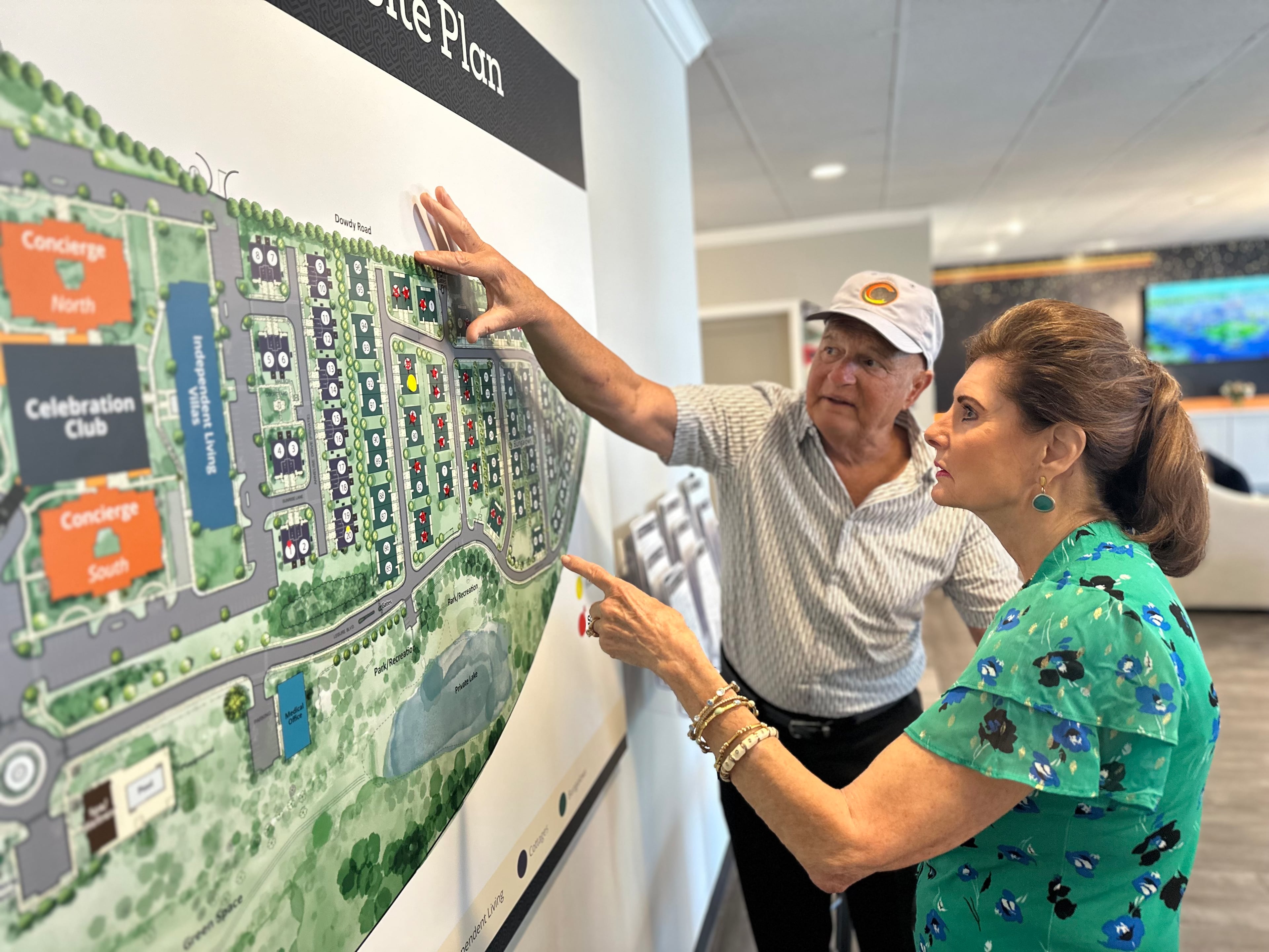 Future resident Dona Stanton and developer Armand Vari discuss renderings of Celebration Village Athens, a senior living community set to open in 2026. (Fletcher Page/AJC)