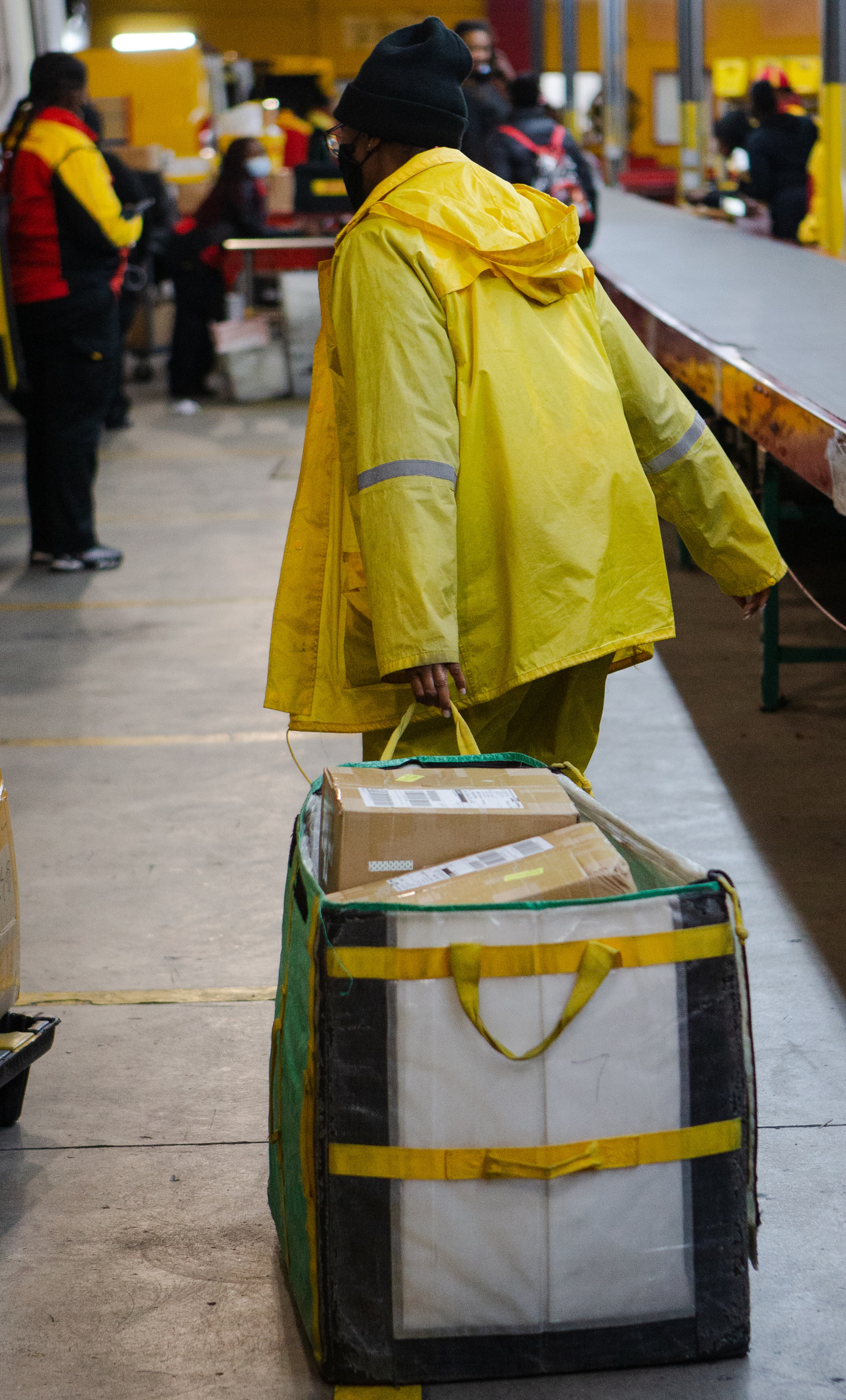 A DHL employee drags a container of boxes across the DHL Express shipping center on Wednesday, December 16, 2020, in Atlanta. Workers at the shipping center worked to fulfill orders during the holiday rush. CHRISTINA MATACOTTA FOR THE ATLANTA JOURNAL-CONSTITUTION.
