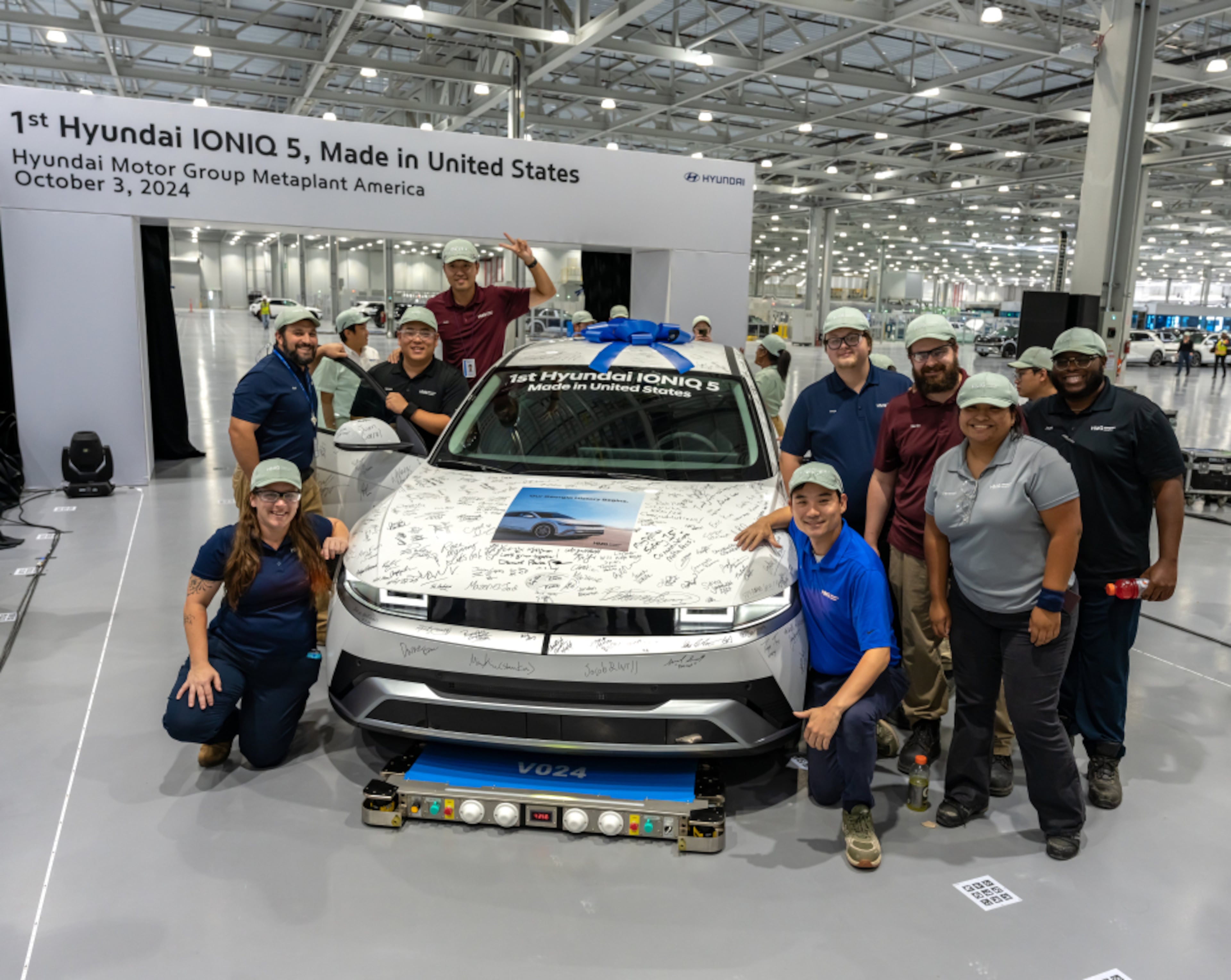 Employees gather around an IONIQ 5 during a start of production celebration at the Hyundai Metaplant on Thursday, Oct. 3, 2024, to sign a SUV celebrating the first saleable vehicle off the line. (Courtesy of Hyundai Motor Group Metaplant America)