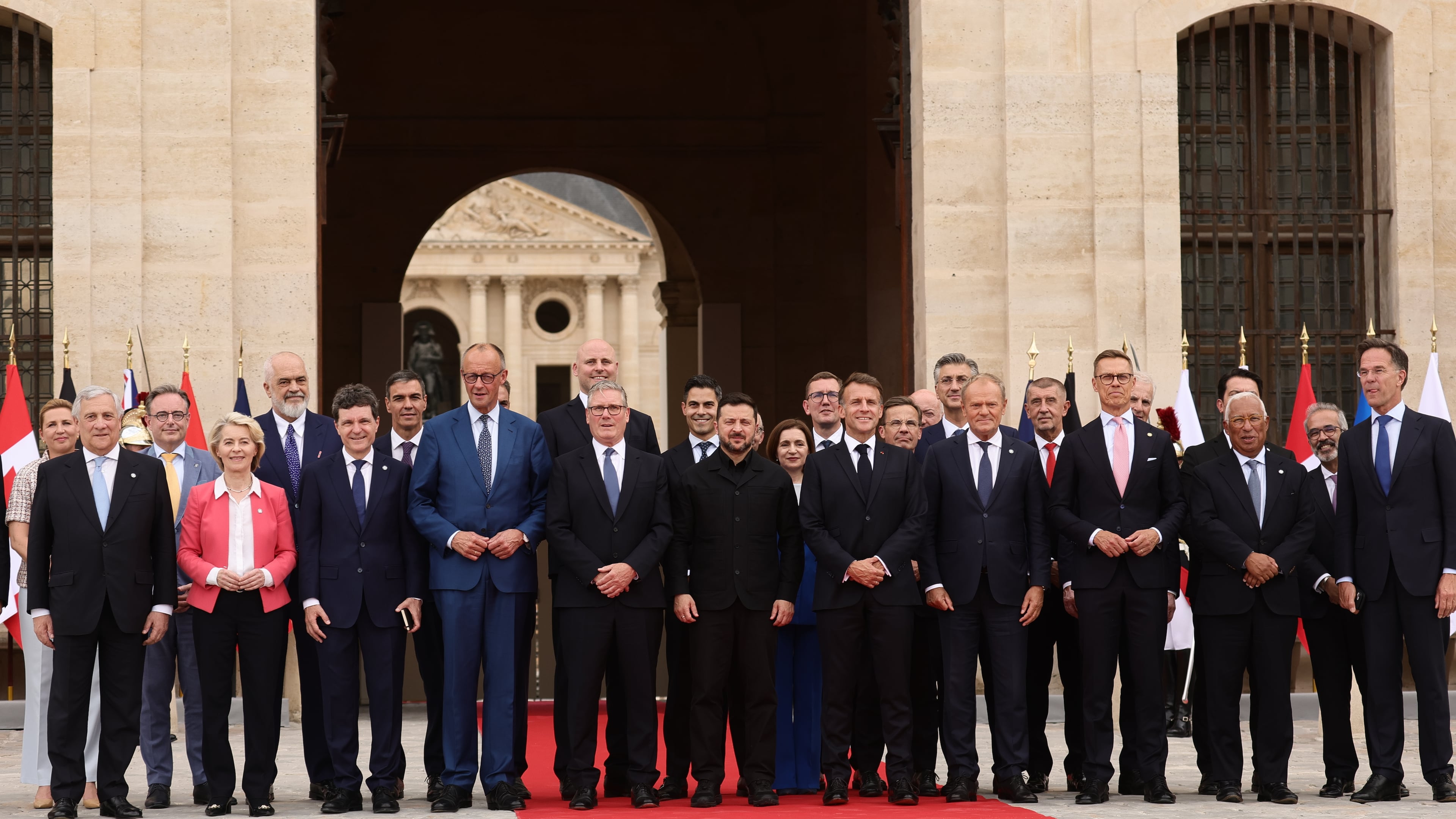 French President Emmanuel Macron and Ukrainian President Volodymyr Zelensky pose for a group photo with heads of states and governments ahead of the Coalition of the Willing summit on security guarantees for Ukraine at the Hotel des Invalides in Paris, France, Monday, July 13, 2026. (Teresa Suarez/POOL photo via AP)