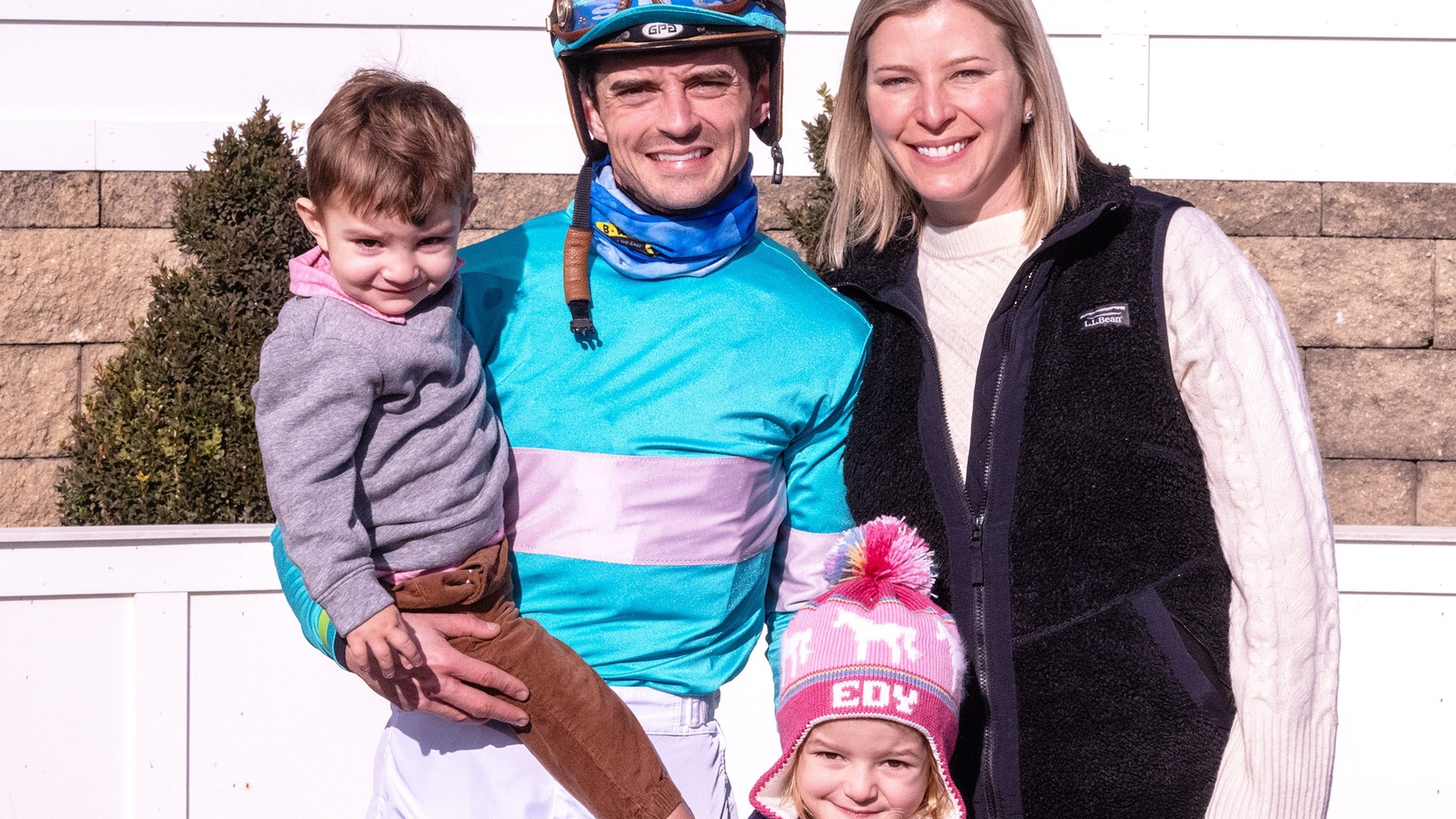 In this image provided by the The Maryland Jockey Club, husband and wife, jockey Sheldon Russell and trainer Brittany Russell, pose for a photo in the winner's circle with son Rye and daughter Edy, after Point Dume won the third race, Dec. 31, 2023, at Laurel Park in Laurel, Md. (Jim McCue/The Maryland Jockey Club via AP)