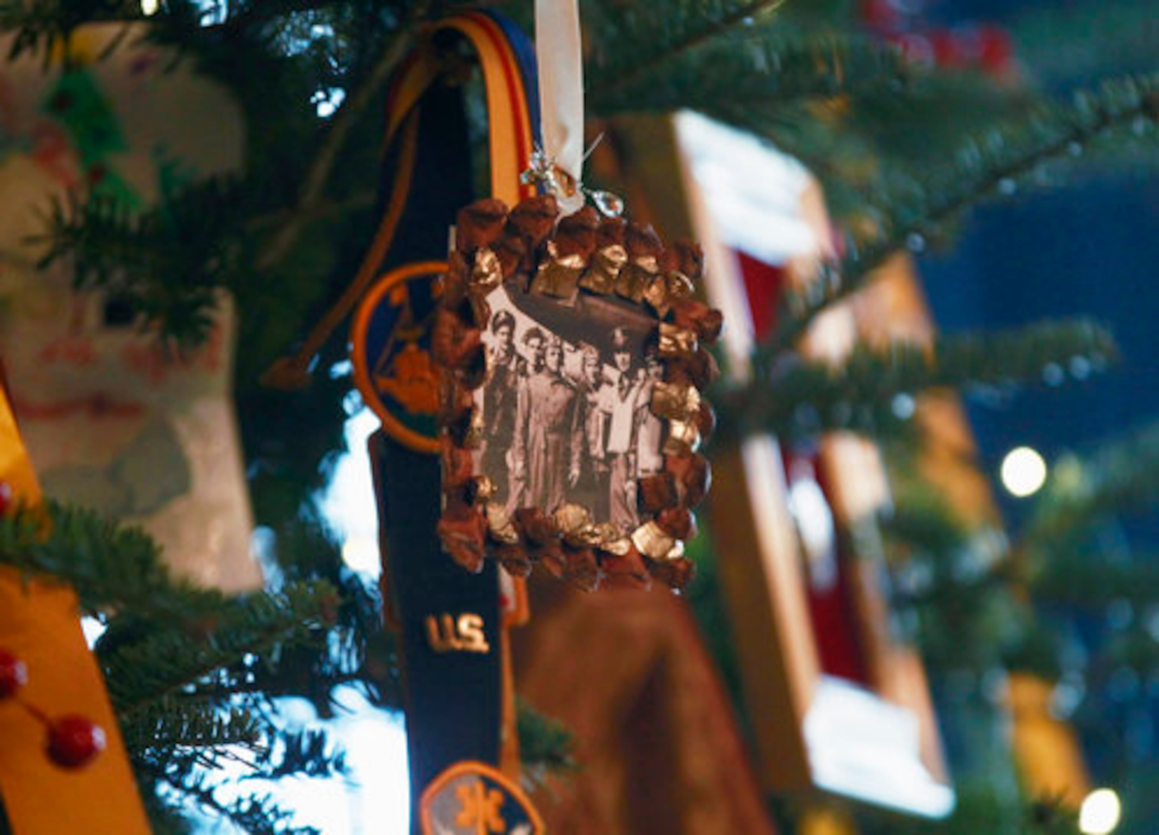 Photographs and insignia are seen on the official White House Christmas Tree in the Blue Room.