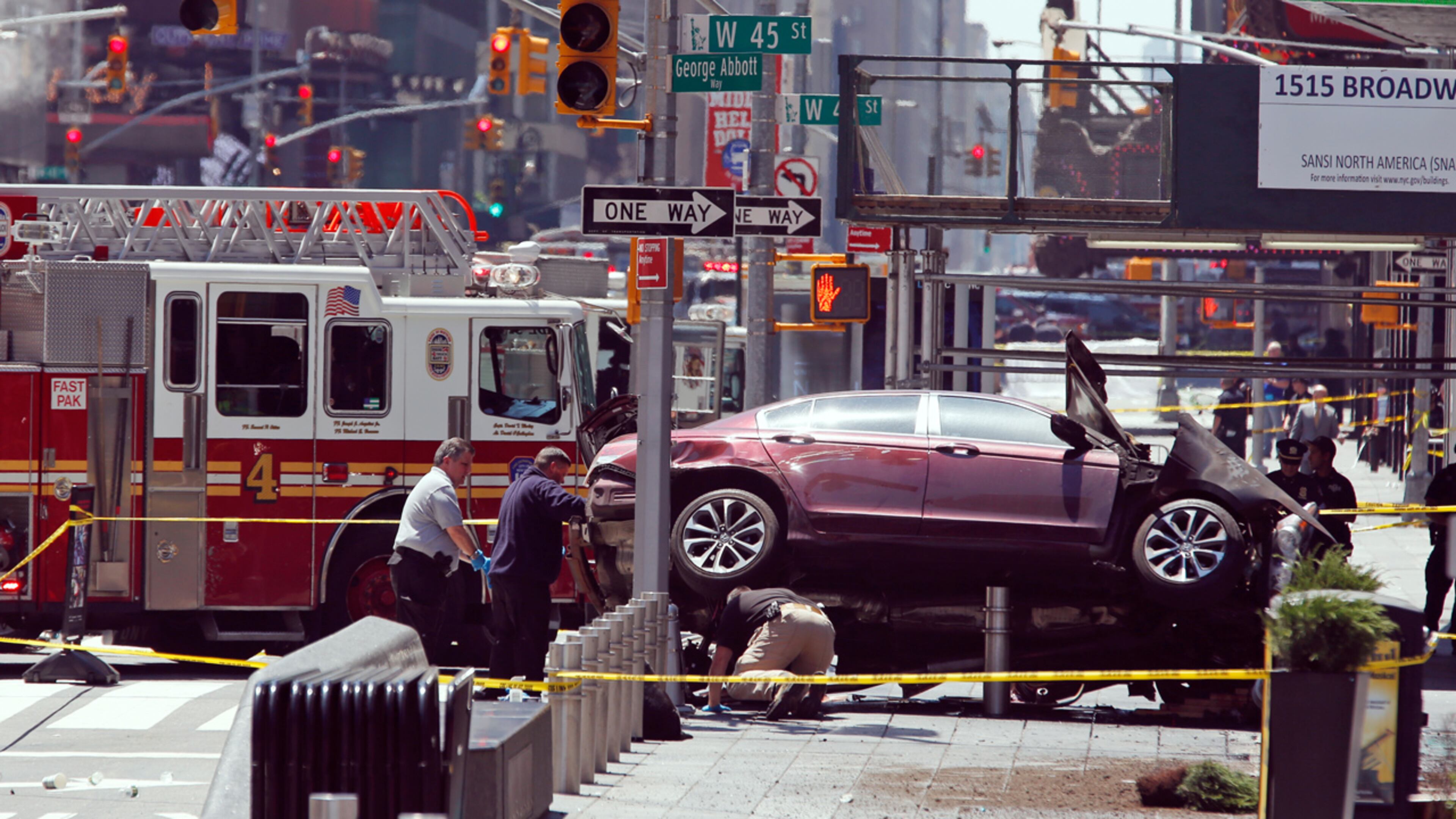 Investigators look under a smashed car that sits on the corner of Broadway and 45th Street in New York's Times Square after ploughing through a crowd of pedestrians. (AP Photo/Seth Wenig)