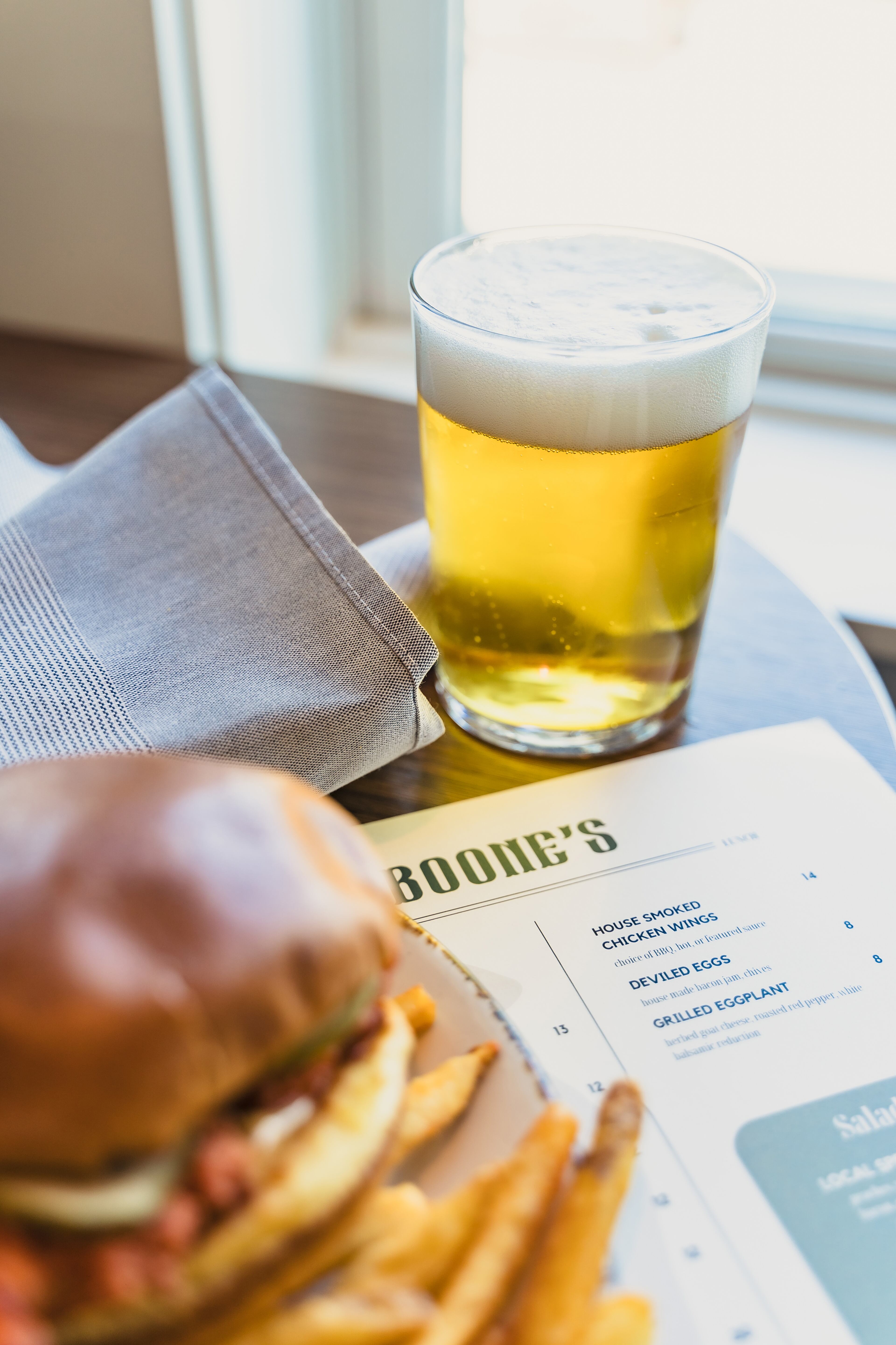 At Boone's Restaurant, which boasts scenic views of the historic Bobby Jones Golf Course, you can raise a glass to Jones with a Calamity Jane golden ale, an ode to the golfer's famous putter. The beer pairs well with Boone's fried chicken sandwich. (Courtesy of Melle Houston)